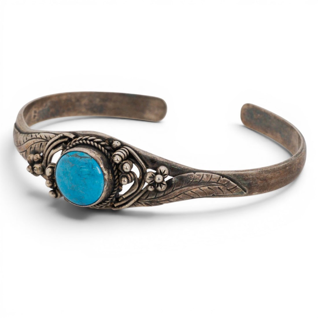 Vintage Navajo Sterling Silver & Turquoise Cuff Bracelet: Vintage Navajo Sterling Silver & Turquoise Cuff Bracelet 1970s-1980s, USA Sterling silver cuff bracelet centered by a round turquoise cabochon in a rope-twist bezel, surrounded by applied wirework and