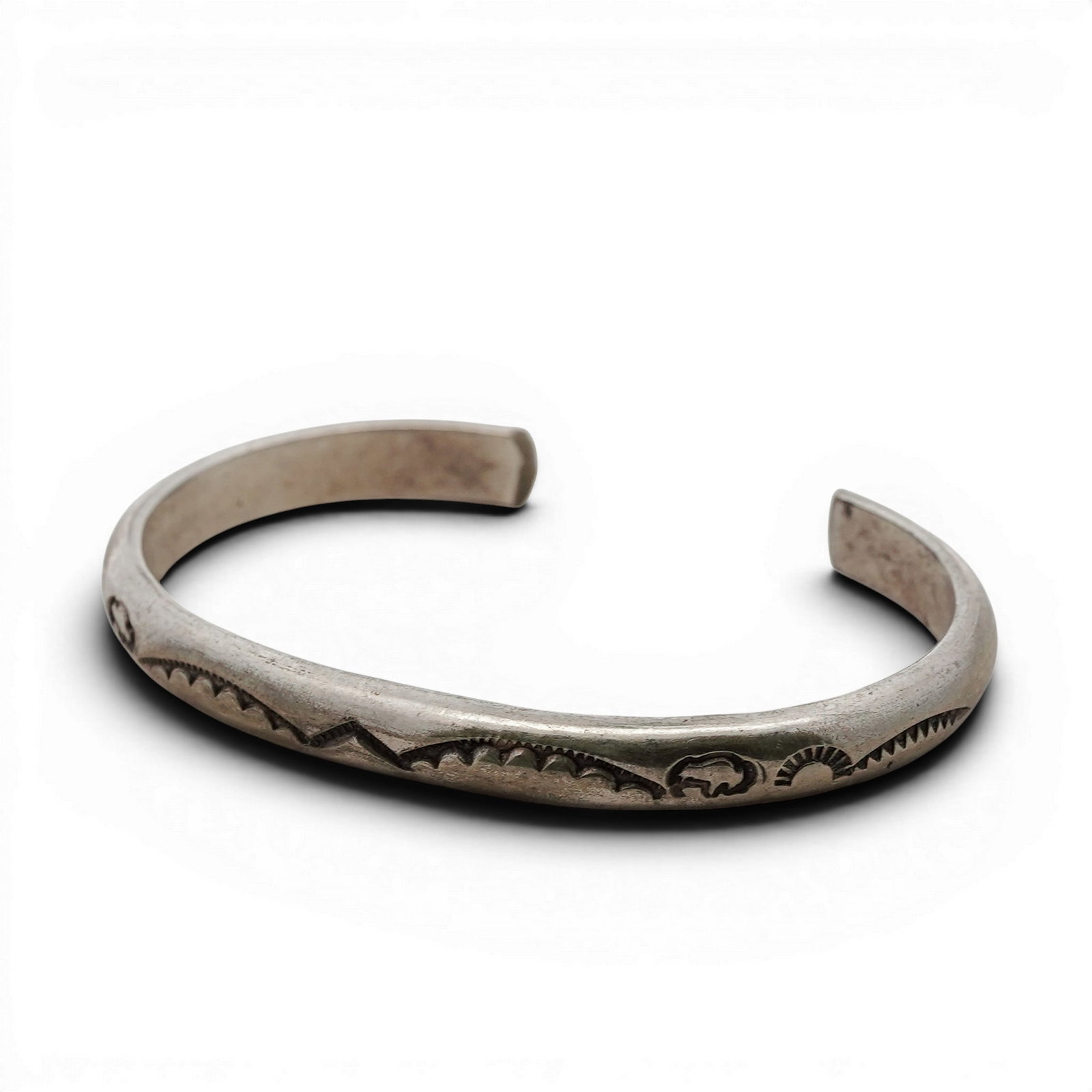 Vintage Navajo Sterling Silver Hand-Stamped Slim Cuff Signed: Vintage Navajo Sterling Silver Hand-Stamped Slim Cuff Signed 1970s-1980s, USA Sterling silver cuff with hand-stamped geometric and crescent motifs along a gently contoured band. Interior stamped “ST