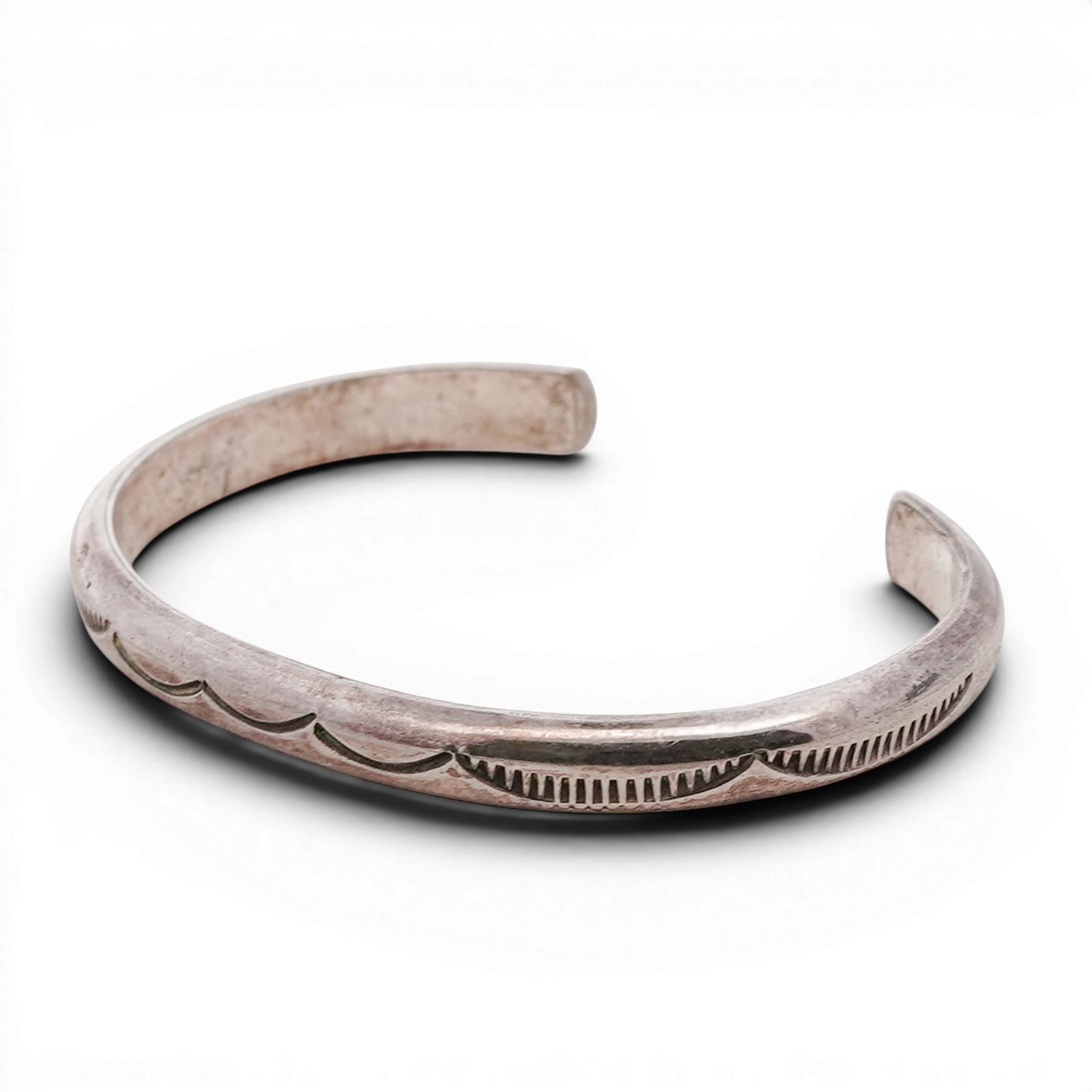 Navajo Sterling Silver Stamped Cuff Bracelet: Navajo Sterling Silver Stamped Cuff Bracelet 1970s-1980s, USA Navajo sterling silver cuff bracelet with a solid silver band featuring stamped scalloped motifs across the top and vertical line accents 