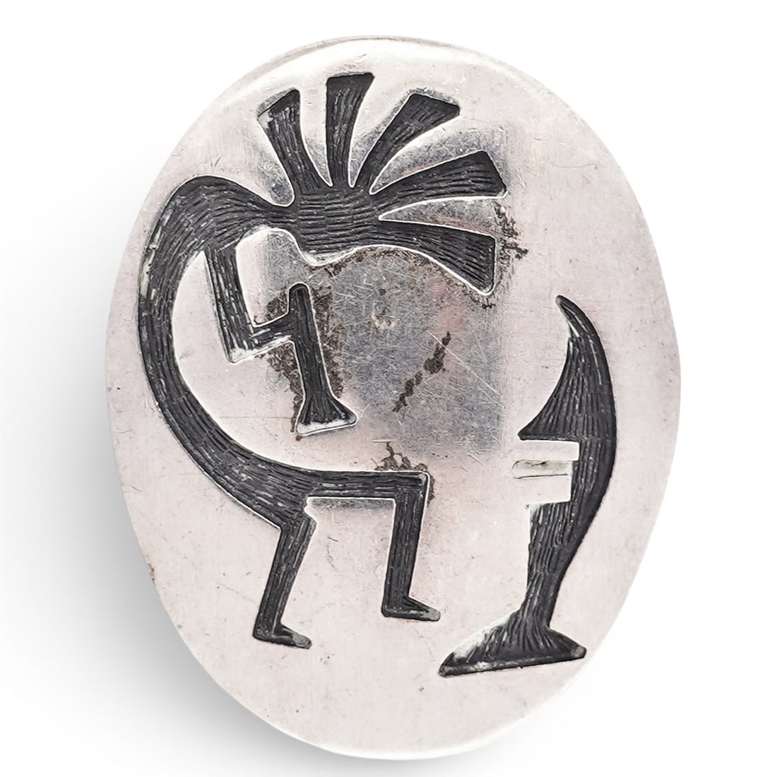 Vintage Navajo Sterling Silver Kokopelli Overlay Pendant Brooch: Vintage Navajo Sterling Silver Kokopelli Overlay Pendant Brooch Late 20th Century, USA Vintage Navajo sterling silver oval-form pendant brooch featuring a cutout Kokopelli figure in profile with radia