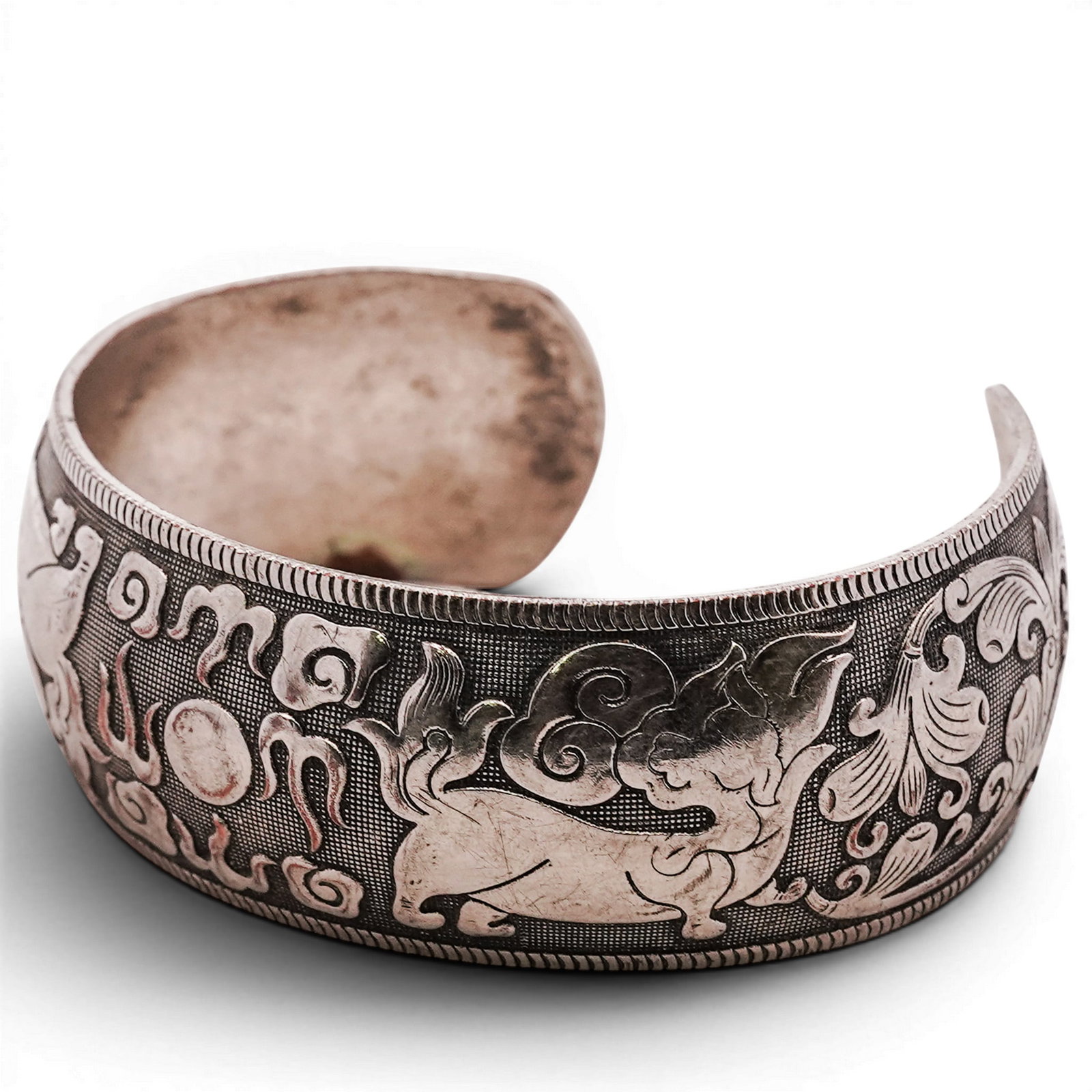 Chinese Silver Mythical Beast Cuff Bracelet: Chinese Silver Mythical Beast Cuff Bracelet Late 20th Century, Chinese Wide silver cuff with repoussé decoration of stylized mythical beasts (dragon/pixiu forms) amid scrolling cloud motifs over a fi