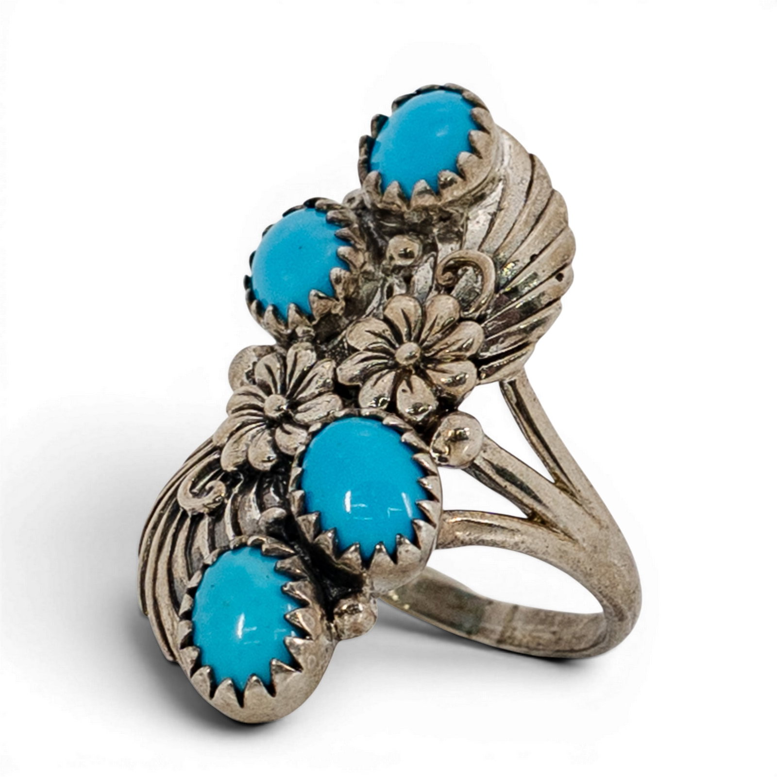 Southwestern Sterling Silver & Turquoise Floral Ring: Southwestern Sterling Silver & Turquoise Floral Ring 1970s-1980s, USA Sterling silver ring featuring five oval turquoise cabochons set in serrated bezels, arranged in a staggered layout. The stones ar
