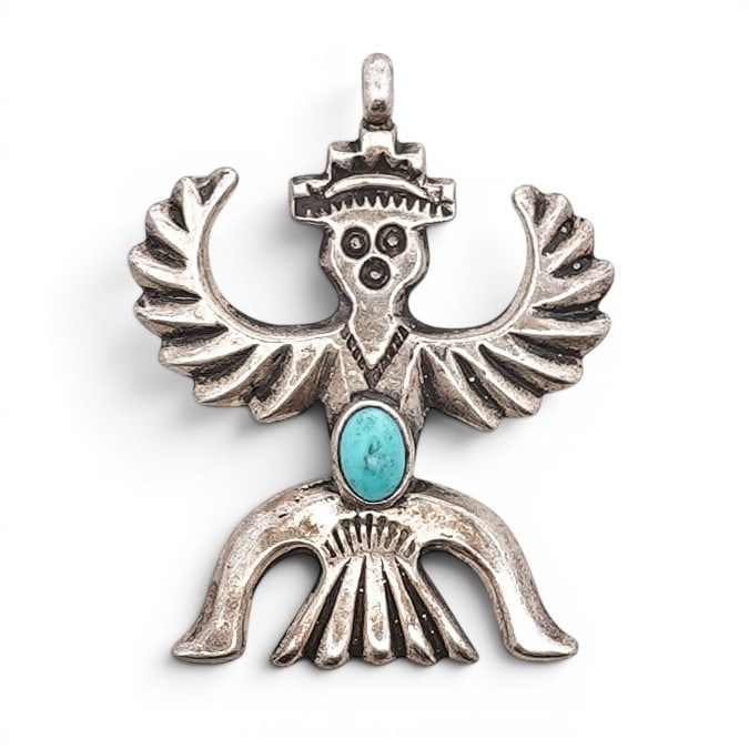 Vintage Navajo Sterling Silver & Turquoise Thunderbird Pendant: Vintage Navajo Sterling Silver & Turquoise Thunderbird Pendant 1970s–1980s, USA Sterling silver figural pendant in the form of a thunderbird, set with an oval turquoise cabochon at the center. The w