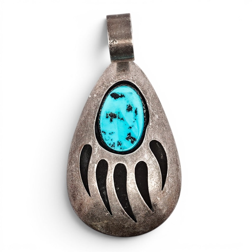 Vintage Navajo Sterling Silver & Turquoise Bear Paw Pendant: Vintage Navajo Sterling Silver & Turquoise Bear Paw Pendant Late 20th century, USA Sterling silver pendant set with an oval turquoise cabochon exhibiting natural matrix within a serrated bezel, within