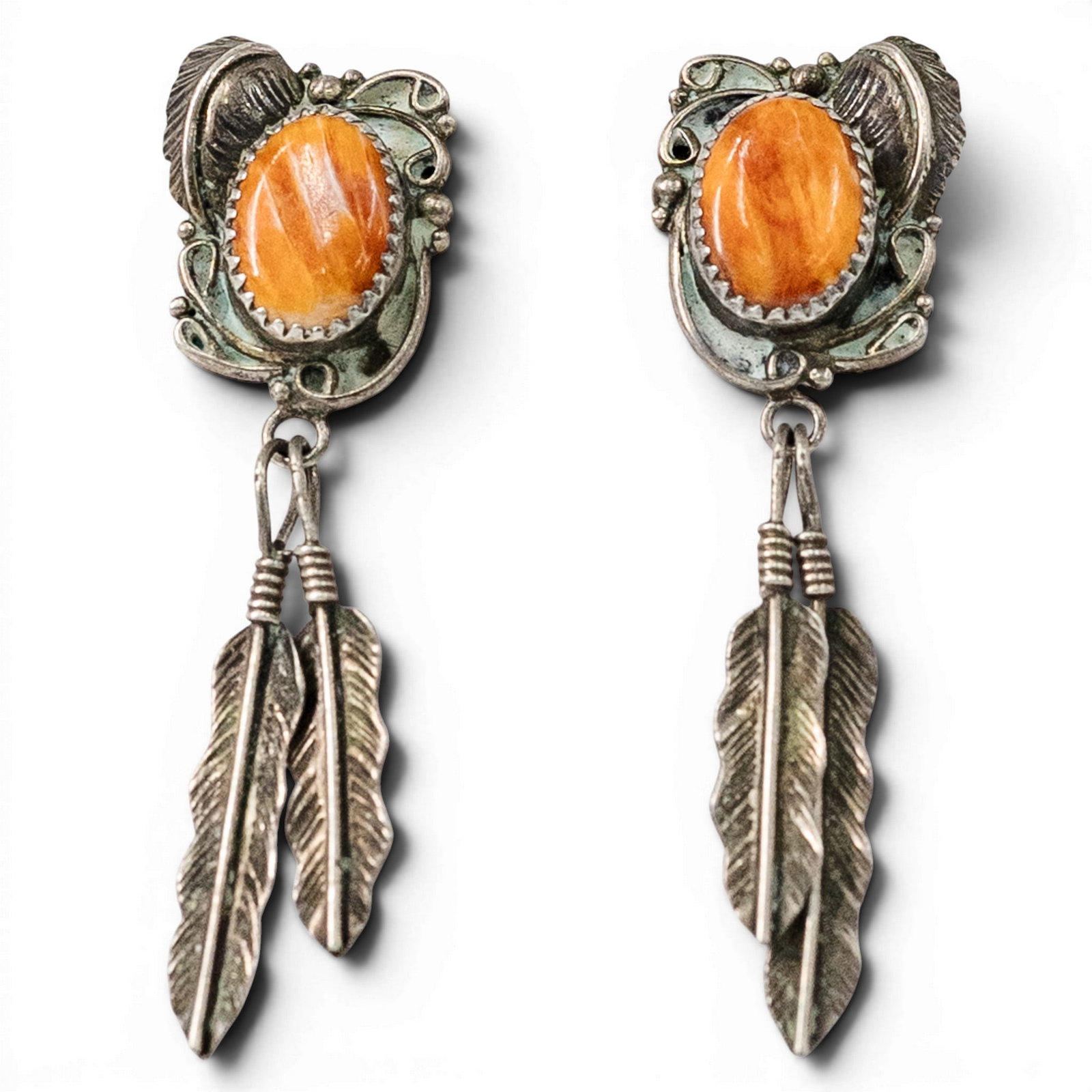 Ricky Ortiz Southwestern Sterling Silver & Spiny Oyster Feather Earrings: Ricky Ortiz Southwestern Sterling Silver & Spiny Oyster Feather Earrings 1980s–1990s, USA Pair of Southwestern sterling silver earrings by Ricky Ortiz set with oval orange spiny oyster cabochons in 
