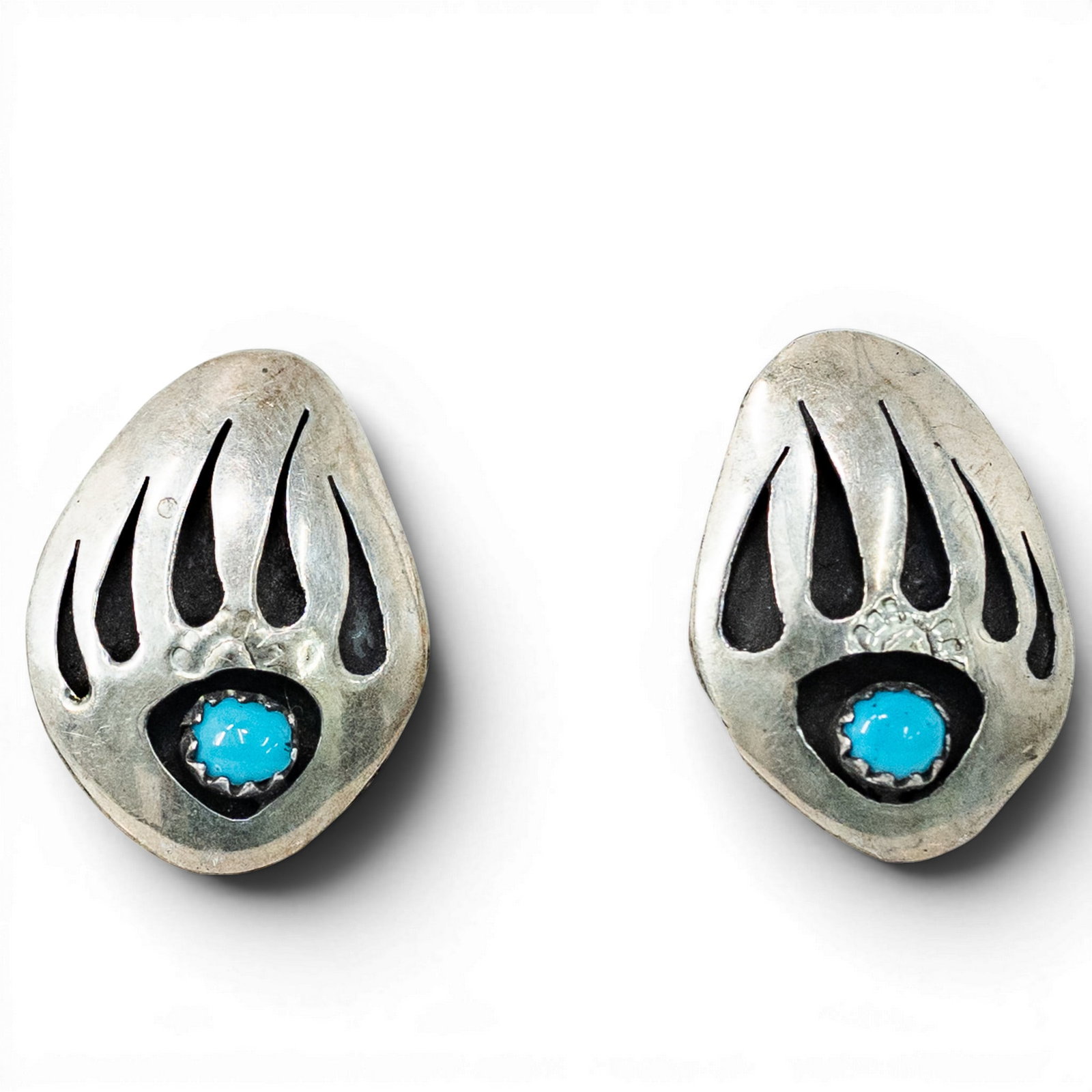 Vintage Navajo Sterling Silver & Turquoise Bear Paw Earrings: Vintage Navajo Sterling Silver & Turquoise Bear Paw Earrings 1970s–1980s, USA Pair of Navajo sterling silver earrings in stylized bear paw form set with round turquoise cabochons within serrated bez