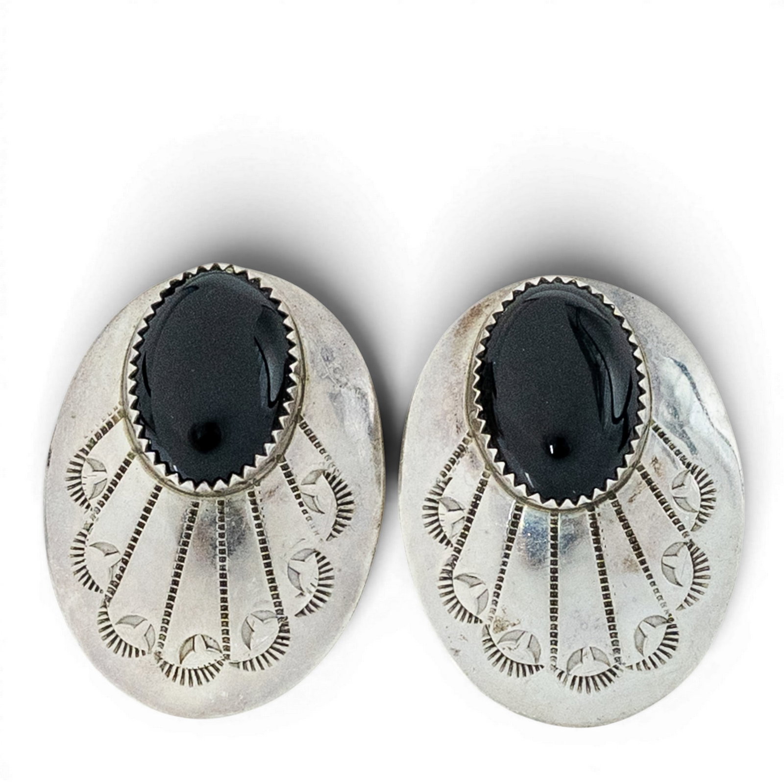 Vintage Navajo Sterling Silver & Black Onyx Stamped Earrings: Vintage Navajo Sterling Silver & Black Onyx Stamped Earrings 1970s, USA Sterling silver oval earrings set with elongated black onyx cabochons in serrated bezel settings over hand stamped fan motif pla