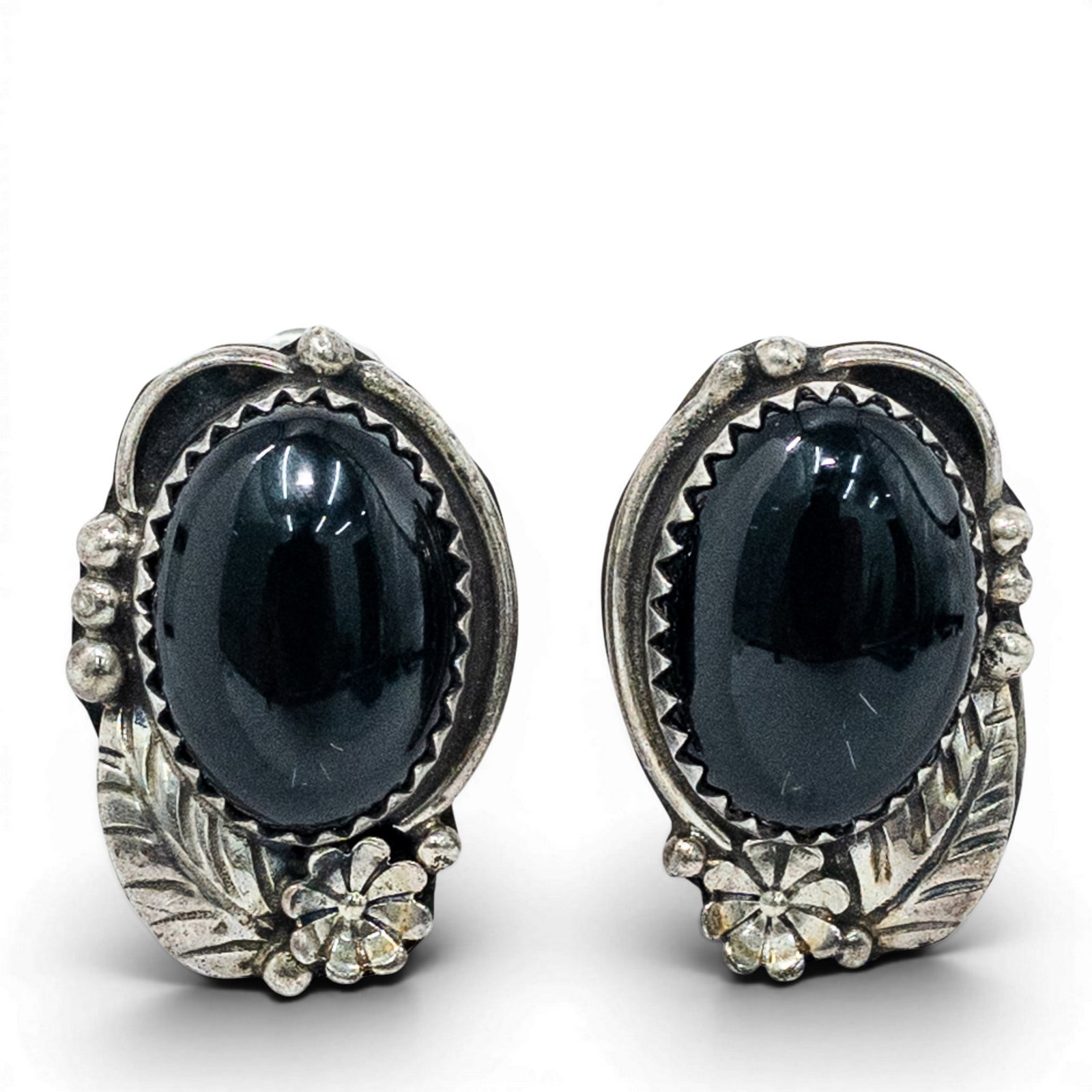 Vintage Navajo Black Onyx Sterling Silver Floral Earrings Signed: Vintage Navajo Black Onyx Sterling Silver Floral Earrings Signed 1960s-1970s, USA Vintage Navajo earrings featuring oval black onyx cabochons set in serrated bezel settings, mounted within asymmetrica