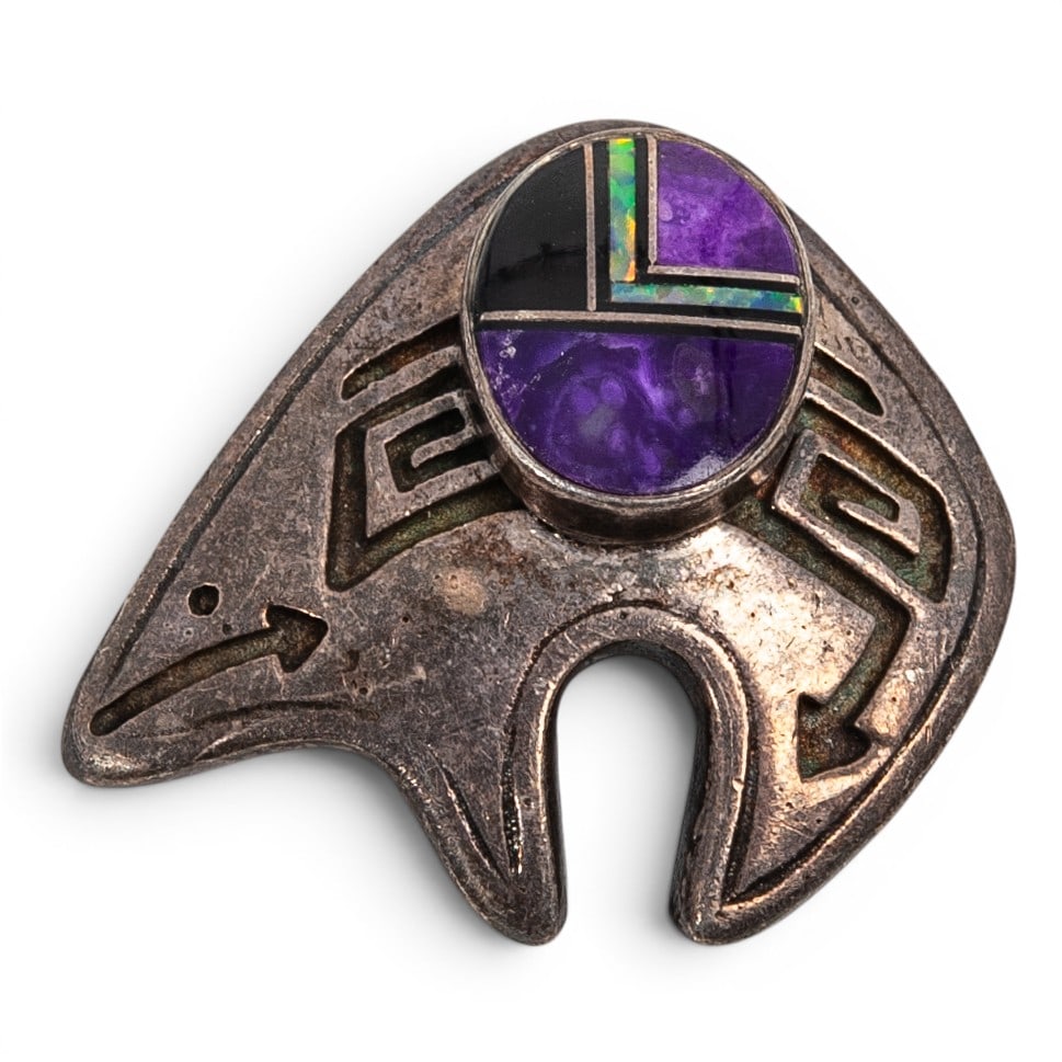 A Southwest sterling silver, sugilite, onyx, and opal inlay bear pendant: A Southwest sterling silver, sugilite, onyx, and opal inlay bear pendant Late 20th century Stamped: Sterling / illegible maker's mark A bear-form pendant with an openwork silhouette and engraved motif
