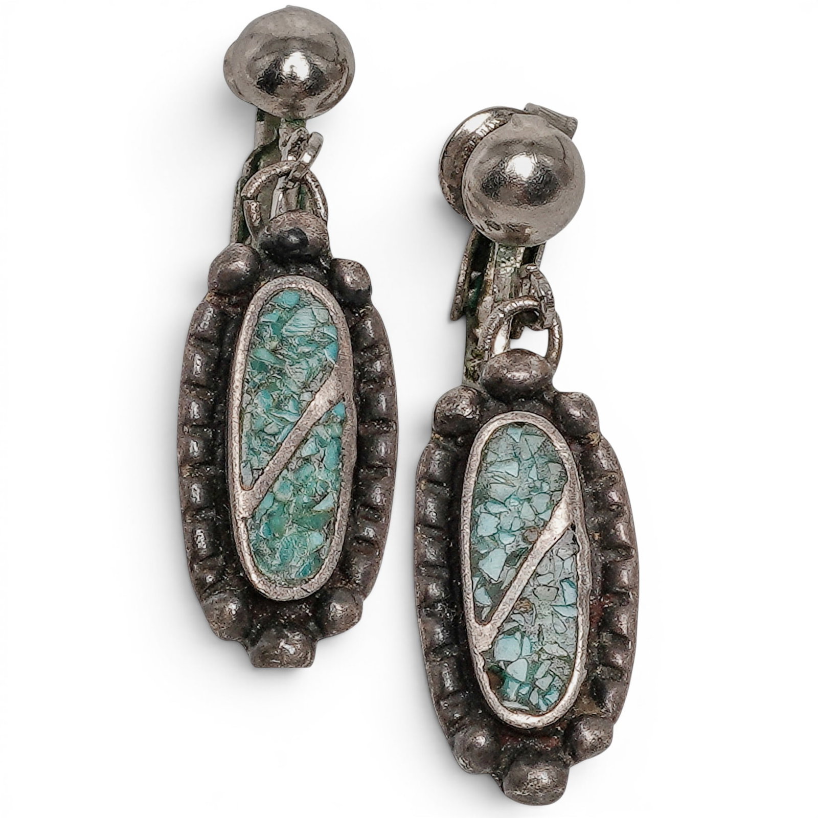 A pair of Southwest sterling silver and turquoise chip inlay dangle earrings: A pair of Southwest sterling silver and turquoise chip inlay dangle earrings Late 20th century Unmarked. Tests for sterling. A pair of clip-back dangle earrings, each with an elongated oval turquoise 