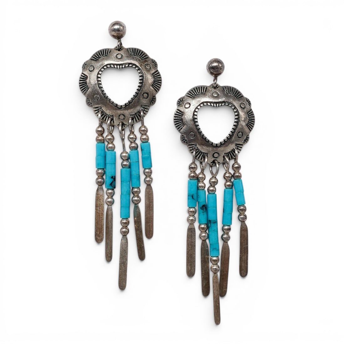 A pair of T.K. Emerson Navajo sterling silver concho fringe earrings: A pair of T.K. Emerson Navajo sterling silver concho fringe earrings Late 20th century Stamped: TK / Sterling A pair of dangle earrings with open heart concho-form tops with hand-stamped decoration, s