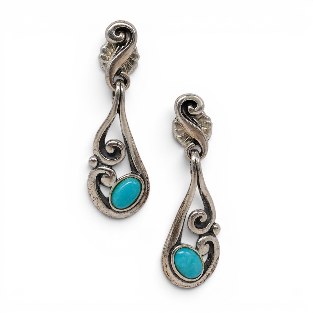 A pair of Carolyn Pollack for Relios sterling silver and turquoise dangle earrings: A pair of Carolyn Pollack for Relios sterling silver and turquoise dangle earrings Late 20th/ 21st century Stamped for Carolyn Pollack / Relios and .925 A pair of open scrollwork dangle earrings, each
