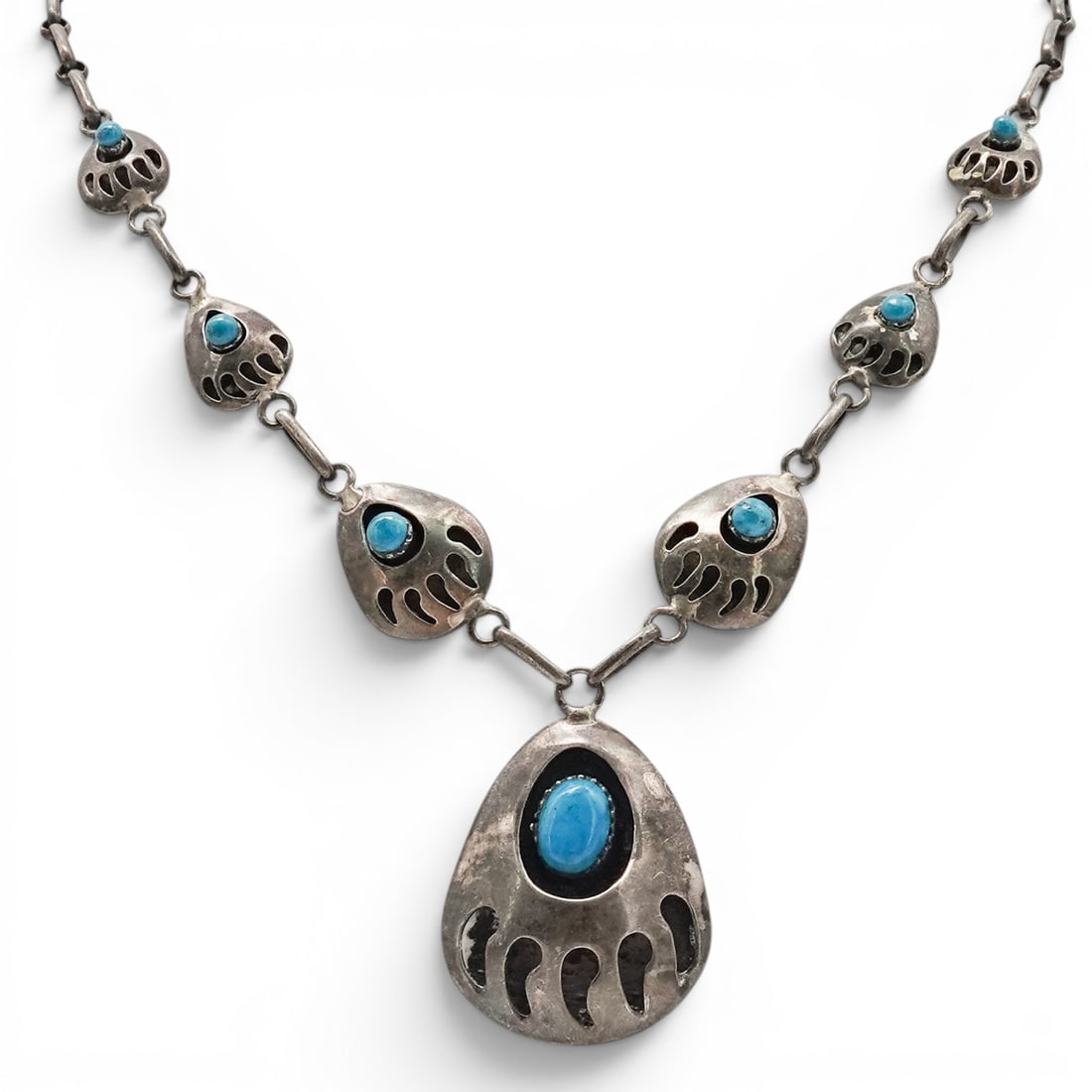 A Southwest sterling silver and turquoise bear claw necklace: A Southwest sterling silver and turquoise bear claw necklace Late 20th century Stamped: .925 A necklace composed of graduated bear claw-form links, each set with turquoise cabochons, terminating in a 