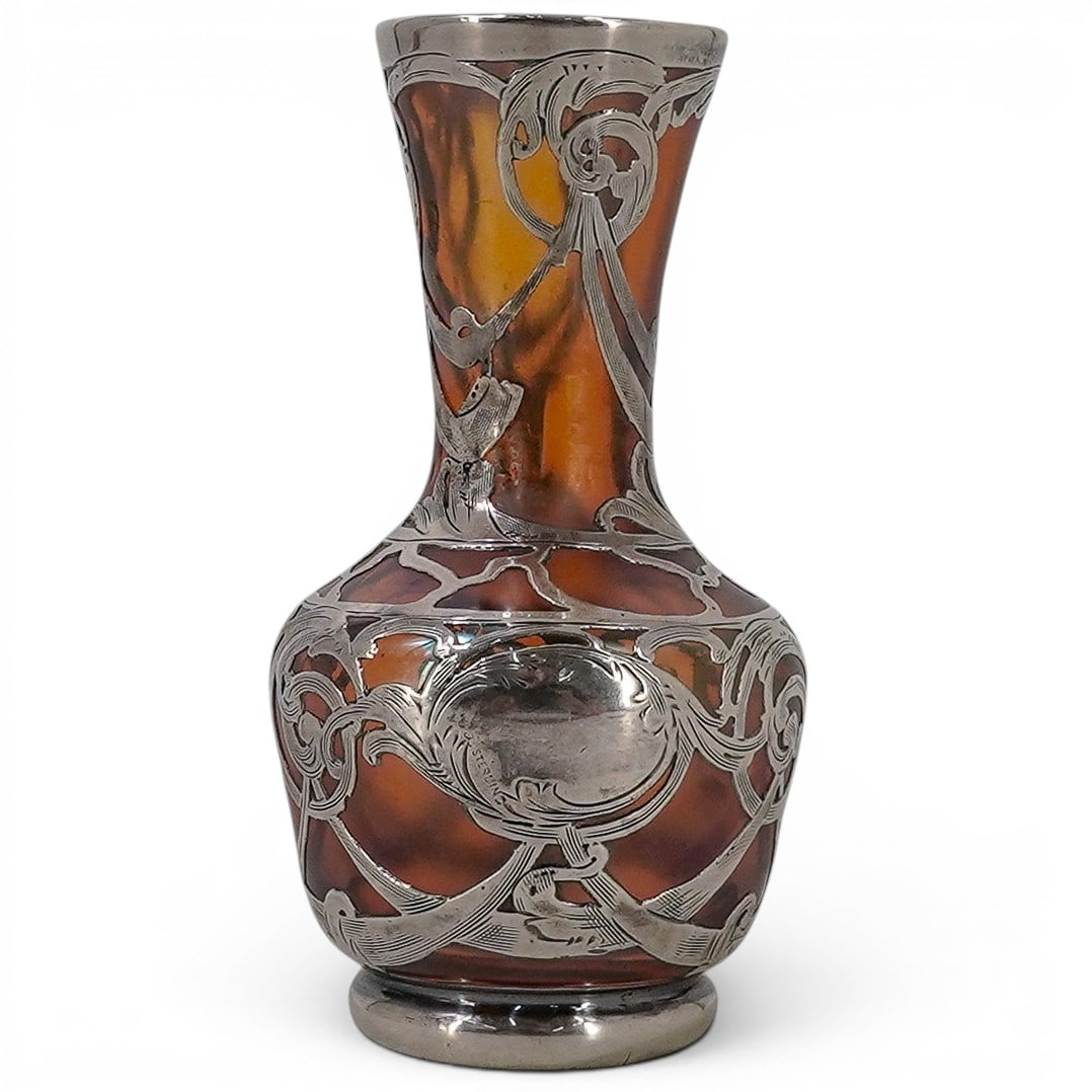 Art Nouveau Sterling Silver & Iridescent Glass Vase: Art Nouveau Sterling Silver & Iridescent Glass Vase Early 20th century A miniature orange iridescent glass featuring an all-over sterling silver floral scroll work mount. Marked on side "sterling". H 