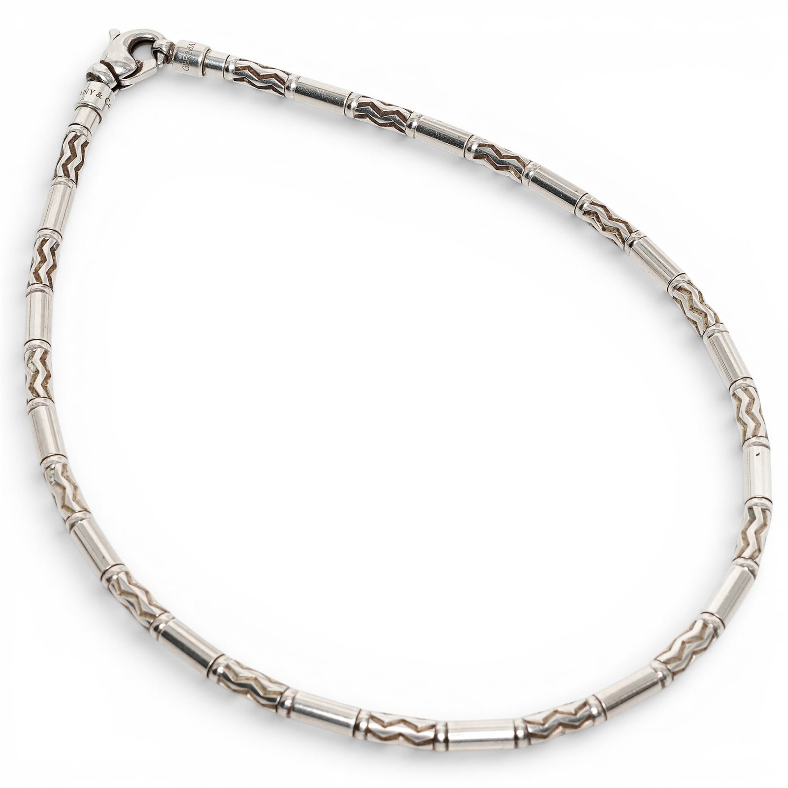 Tiffany & Co. Sterling Silver Articulated Tube Necklace: Tiffany & Co. Sterling Silver Articulated Tube Necklace 1990s, Italian Sterling silver necklace composed of articulated tubular links alternating with raised chevron-patterned sections, completed by a