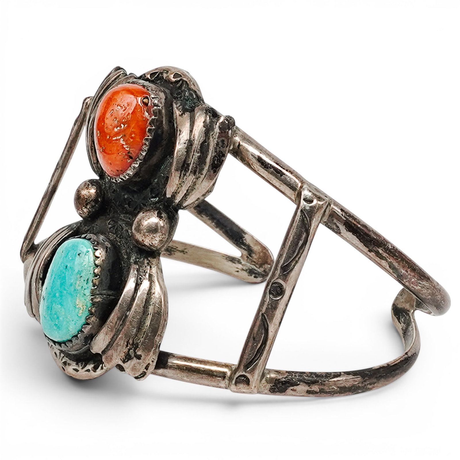 A Signed Navajo Silver, Turquoise, And Coral Cuff Bracelet: A Signed Navajo Silver, Turquoise, And Coral Cuff Bracelet Late 20th century Stamped: R.C. Tested sterling silver. An openwork cuff bracelet with oval turquoise and coral cabochons in serrated bezels,