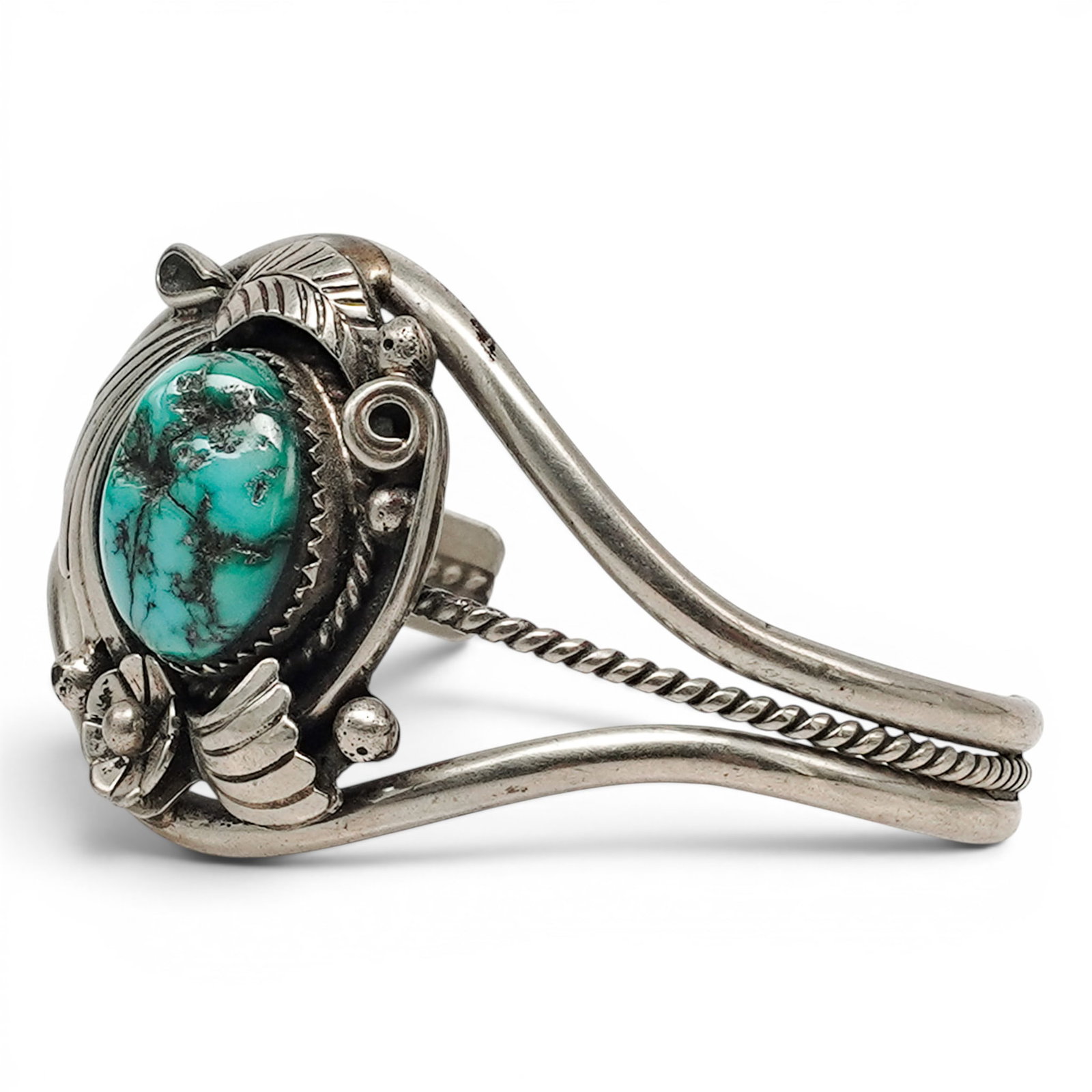 A Navajo Silver And Turquoise Cuff Bracelet: A Navajo Silver And Turquoise Cuff Bracelet Late 20th century Stamped: Illegible hallmark. Tested sterling silver. A cuff bracelet with a central oval turquoise cabochon exhibiting visible matrix, acc