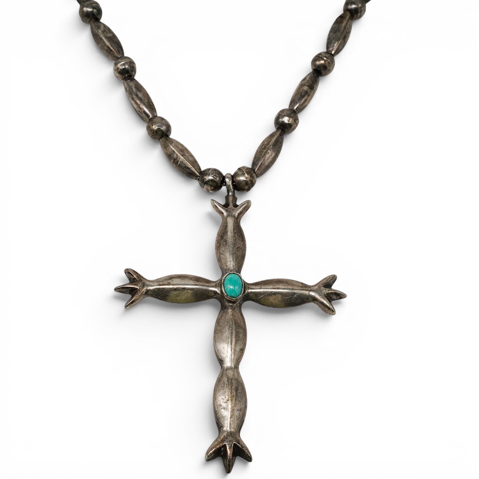 A Navajo Sterling Silver And Turquoise Cross Pendant Necklace: A Navajo Sterling Silver And Turquoise Cross Pendant Necklace Late 20th century Unmarked. Tested sterling silver. A necklace composed of elongated silver bead links suspending a cross-form pendant set