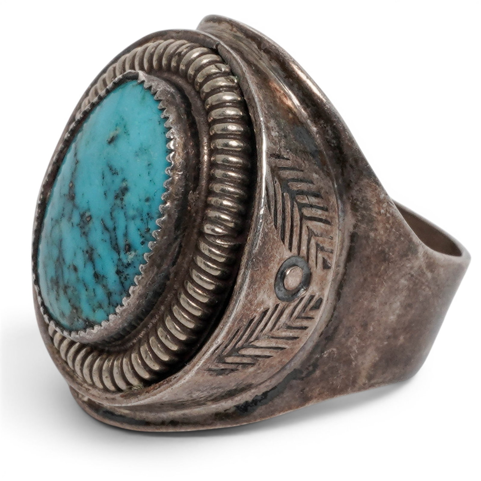 A Navajo Sterling Silver And Turquoise Ring: A Navajo Sterling Silver And Turquoise Ring Late 20th century Stamped: Sterling / .925. A heavy ring with an oval bezel-set turquoise cabochon within a rope-twist border and wide tapering silver shoul