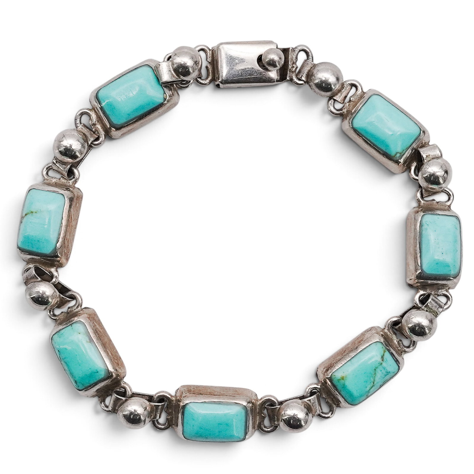 A Mexican Sterling Silver And Turquoise Link Bracelet: A Mexican Sterling Silver And Turquoise Link Bracelet Late 20th century Stamped: Mexico / .925. A link bracelet composed of rectangular bezel-set turquoise cabochons joined by spherical silver connect