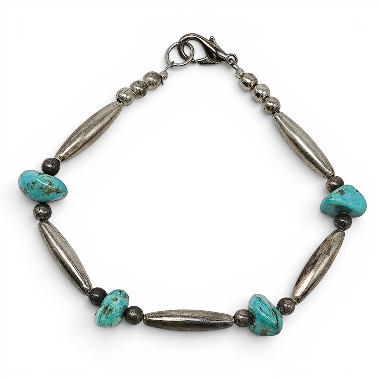 A Navajo Sterling Silver And Turquoise Bead Bracelet: A Navajo Sterling Silver And Turquoise Bead Bracelet Late 20th century Unmarked. Tested sterling silver. A bracelet strung with irregular turquoise nugget beads alternating with elongated silver barre