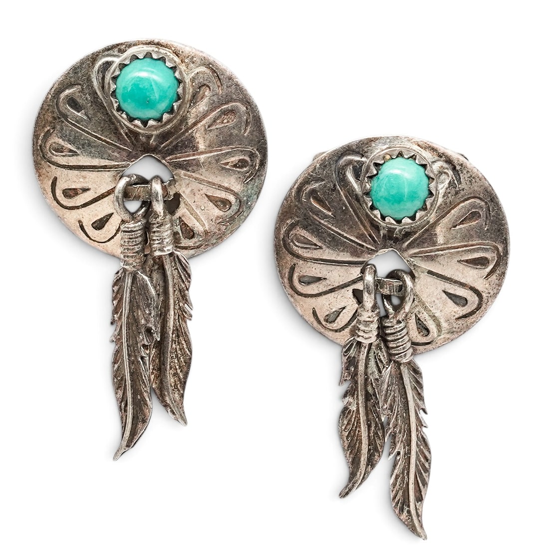 A Pair Of Navajo Sterling Silver And Turquoise Feather Dangle Post Earrings: A Pair Of Navajo Sterling Silver And Turquoise Feather Dangle Post Earrings Late 20th century Unmarked. Tested sterling silver. Each with a round stamped silver concho centered by a bezel-set turquois