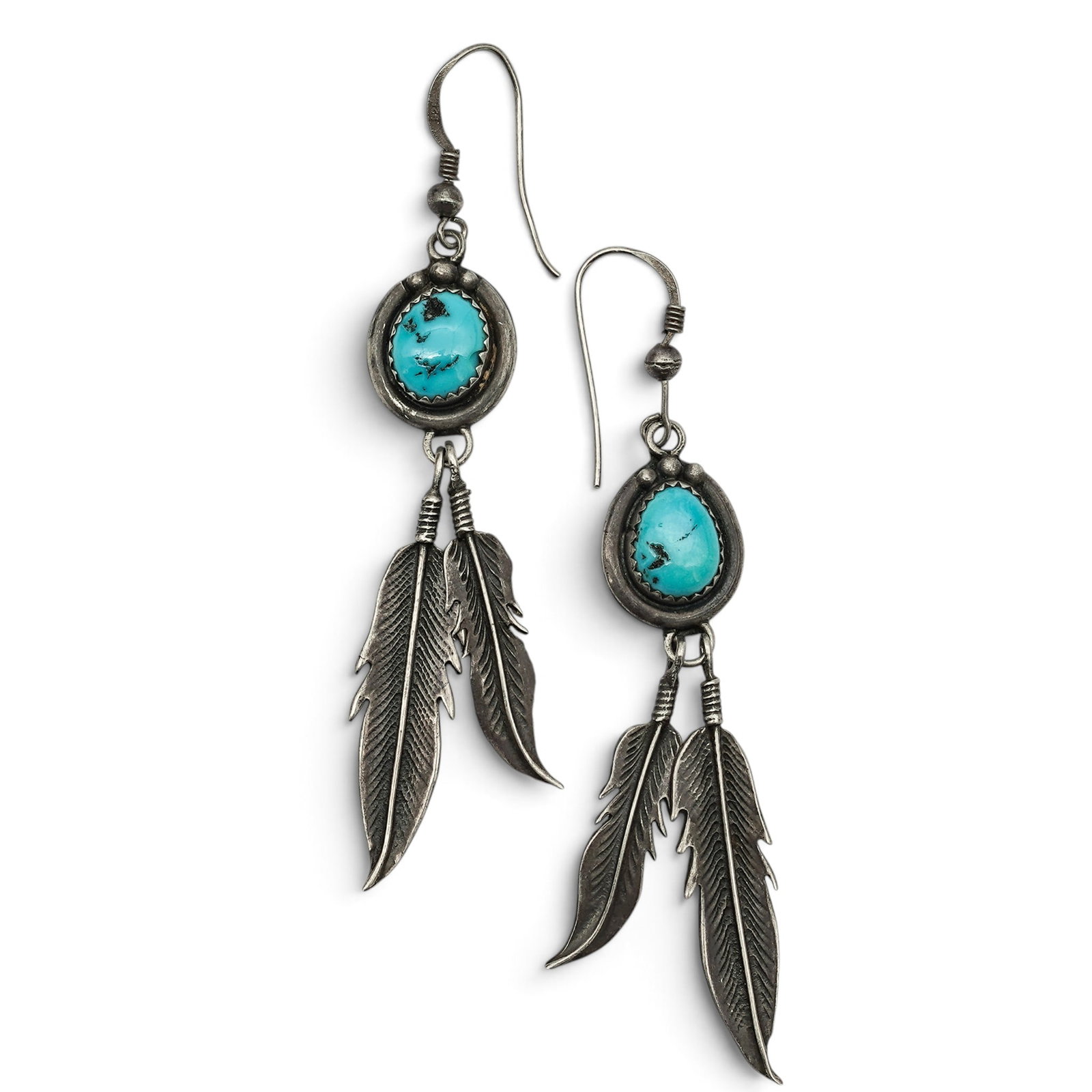 A Pair Of Southwest Sterling Silver And Turquoise Feather Dangle Earrings: A Pair Of Southwest Sterling Silver And Turquoise Feather Dangle Earrings Late 20th century Unmarked Tests for sterling. Each fishhook earring is set with an oval turquoise cabochon in a serrated beze