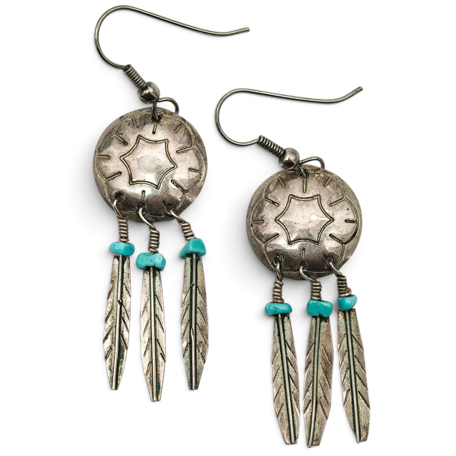 A Pair Of Navajo Sterling Silver And Turquoise Feather Fringe Earrings: A Pair Of Navajo Sterling Silver And Turquoise Feather Fringe Earrings Late 20th century Unmarked Tests for sterling. Each circular earring has stamped sunburst decoration and suspends three feather-f