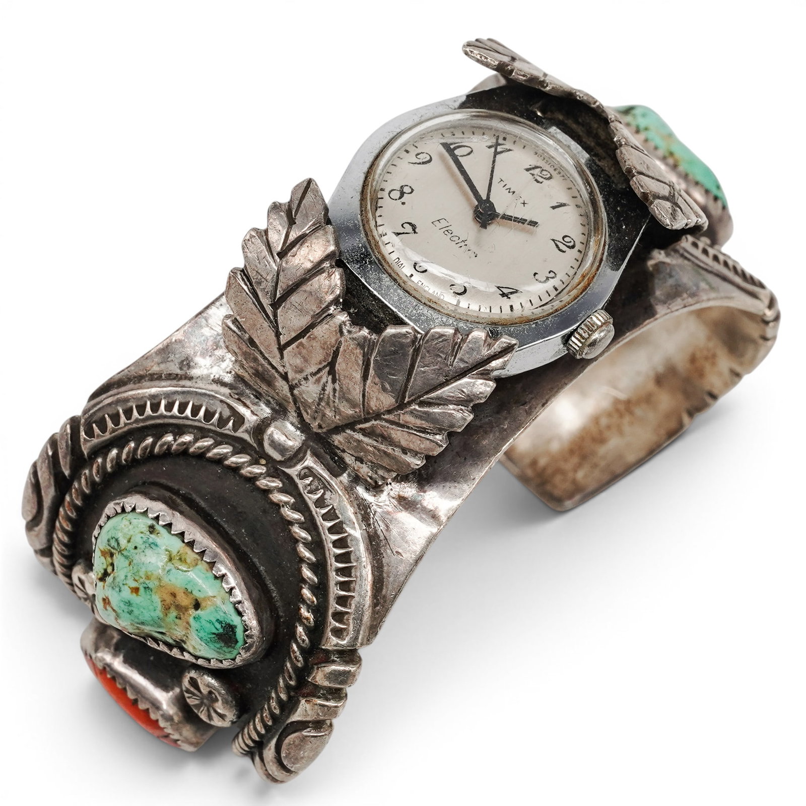 A Donovan Kinsel Navajo Silver, Turquoise, Coral, And Watch Cuff Bracelet: A Donovan Kinsel Navajo Silver, Turquoise, Coral, And Watch Cuff Bracelet Late 20th century Stamped: D.K. Tested sterling silver. A heavy silver watch cuff bracelet centering a Timex Electric wristwat