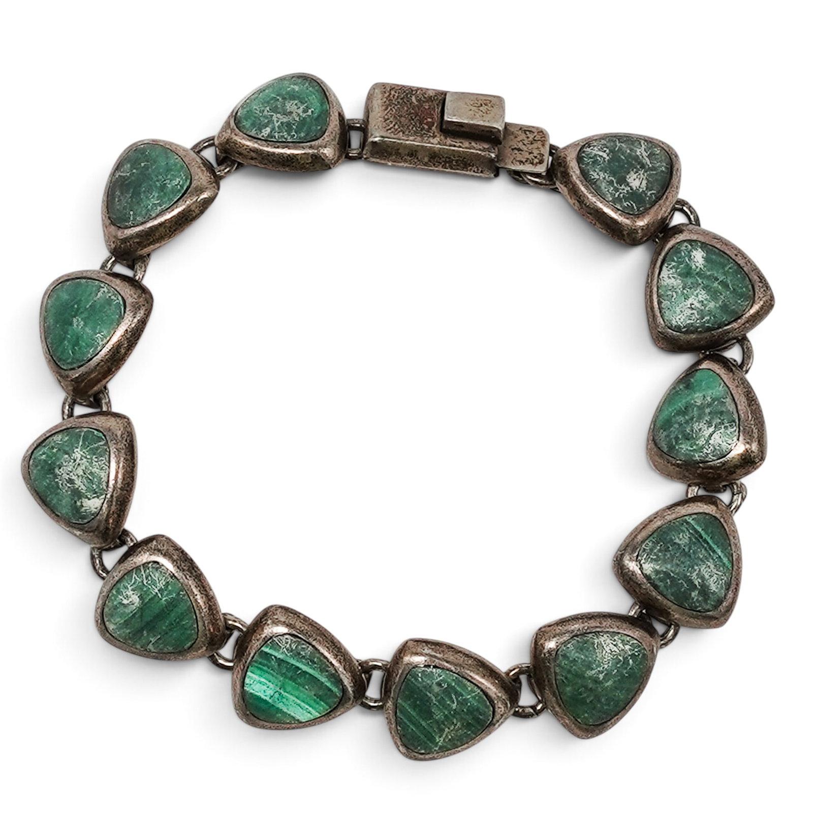 A Mexican Silver And Malachite Link Bracelet: A Mexican silver and malachite link bracelet Late 20th Century Stamped: Mexico / TN-181 / 850. An articulated bracelet composed of triangular malachite cabochons in heavy silver bezel mounts joined by