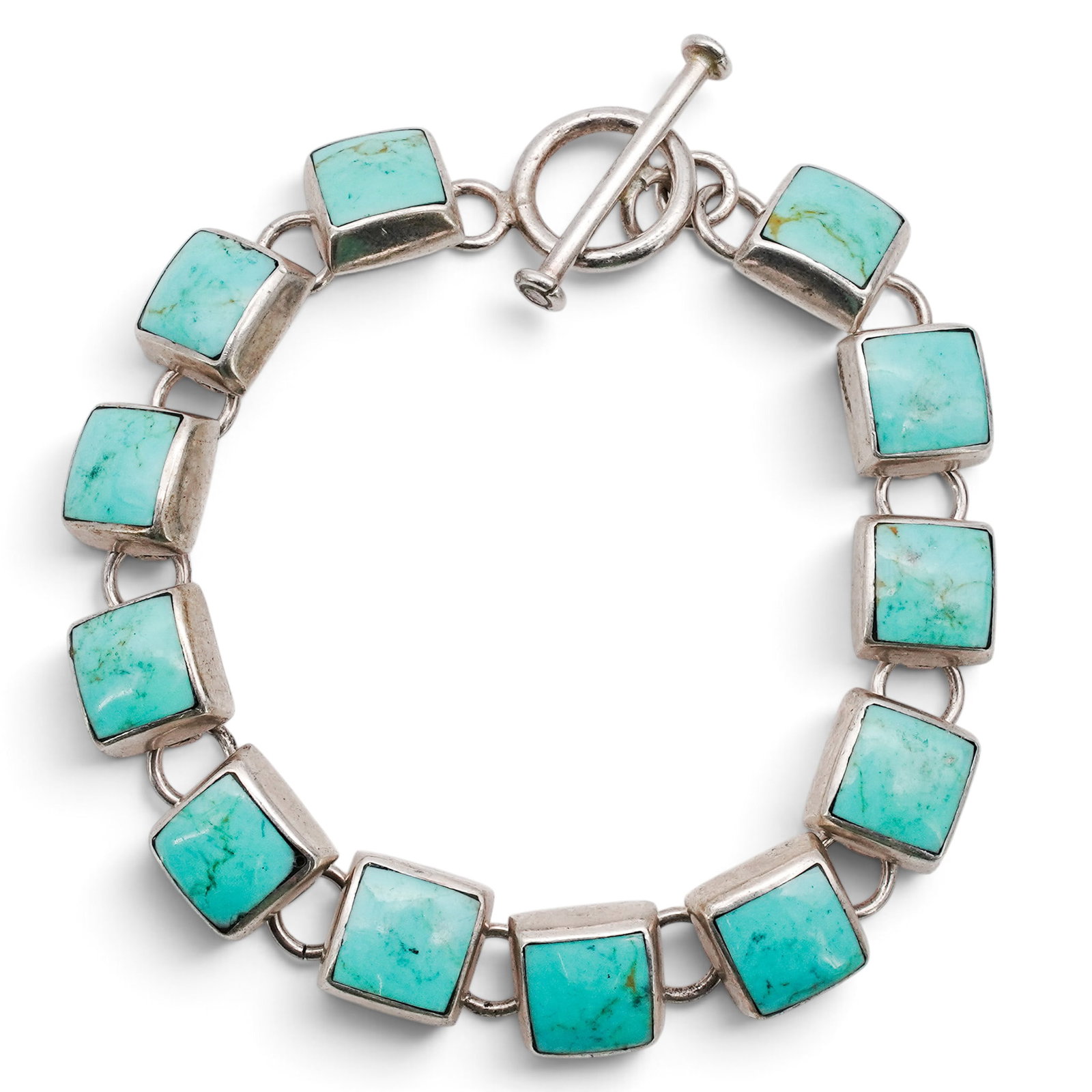 A Mexican Sterling Silver And Turquoise Link Bracelet: A Mexican sterling silver and turquoise link bracelet Late 20th century Stamped: Mexico / .925. An articulated bracelet composed of square bezel-set turquoise cabochons joined by oval connector links.