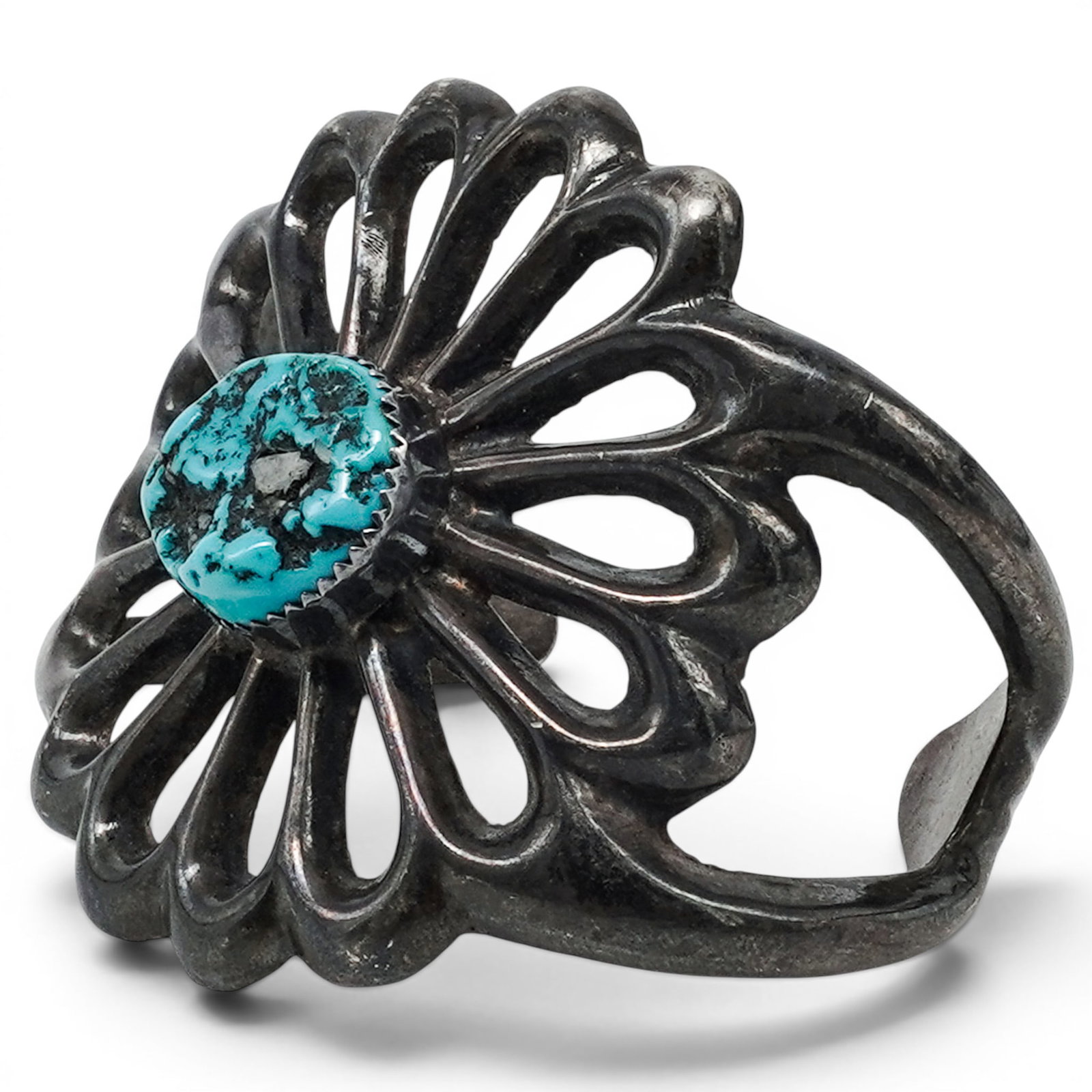 A Navajo Sterling Silver And Turquoise Flower Form Cuff Bracelet: A Navajo sterling silver and turquoise flower form cuff bracelet Late 20th century Unmarked. Tested sterling silver. A substantial cuff bracelet with a large flower-form silver plaque composed of radi