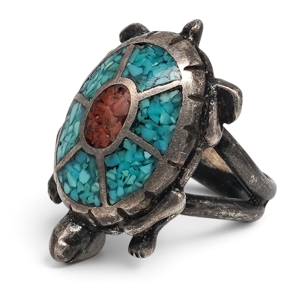 A Navajo Sterling Silver, Turquoise, And Coral Turtle Ring: A Navajo sterling silver, turquoise, and coral turtle ring Late 20th century Unmarked. Tested sterling silver. A turtle-form ring with mosaic inlay turquoise shell segmented by silver channels and cen