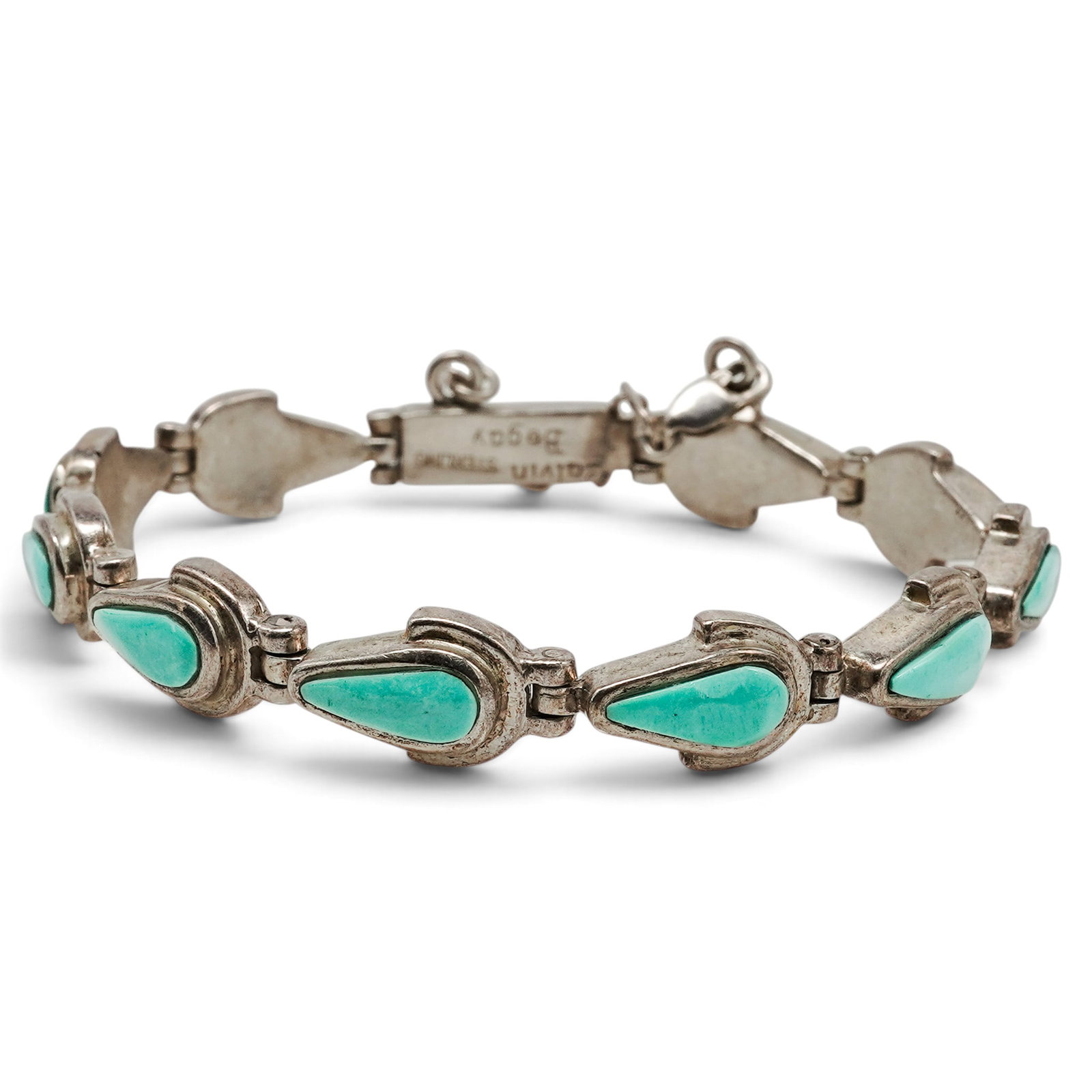 A Calvin Begay Navajo Sterling Silver And Turquoise Link Bracelet: A Calvin Begay Navajo sterling silver and turquoise link bracelet Late 20th century Stamped: Calvin Begay / Sterling. A link bracelet composed of bezel-set turquoise drops joined by articulated links,