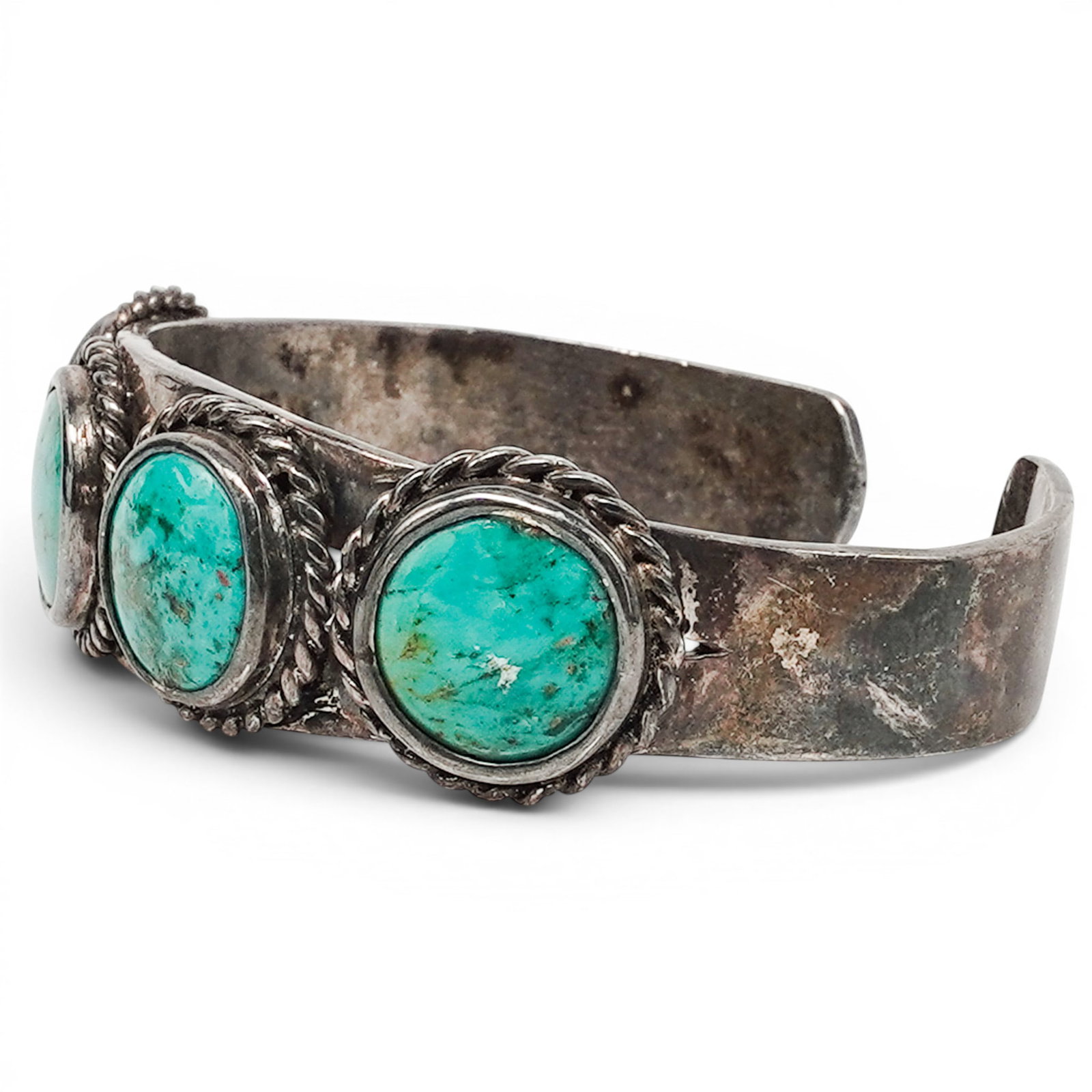 A Navajo Sterling Silver And Turquoise Four Stone Cuff Bracelet: A Navajo sterling silver and turquoise four stone cuff bracelet Late 20th century Stamped: 925. A cuff bracelet with four oval bezel set turquoise cabochons framed by twisted wire borders, with openwo