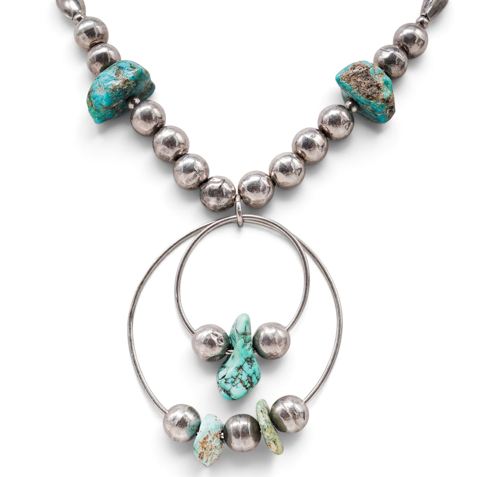 A Navajo Sterling Silver And Turquoise Beaded Necklace With Hoop Pendant: A Navajo sterling silver and turquoise beaded necklace with hoop pendant Late 20th century Unmarked. Tested sterling silver. A necklace composed of silver beads with turquoise nugget accents, suspendi