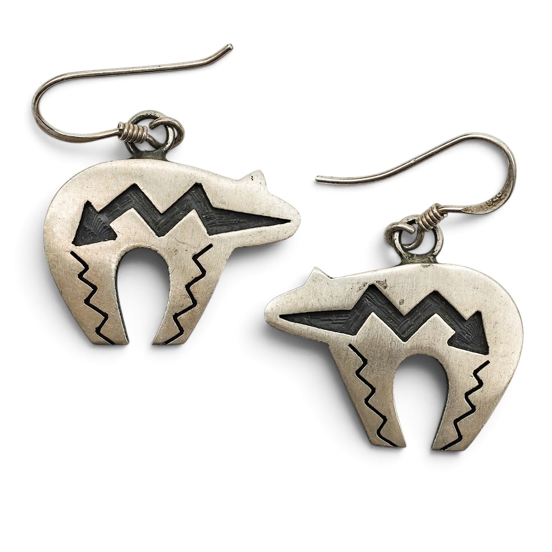 A Pair Of Navajo Sterling Silver Cutout Bear Dangle Earrings: A pair of Navajo sterling silver cutout bear dangle earrings Late 20th century Stamped: [unidentified engraving] Each stylized bear-form earring has pierced and incised geometric decoration with oxidi