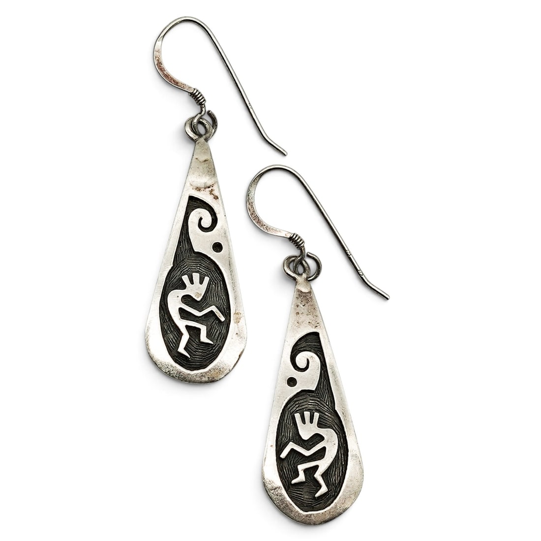 A Pair Of Navajo Sterling Silver Kokopelli Teardrop Dangle Earrings: A pair of Navajo sterling silver Kokopelli teardrop dangle earrings Late 20th century Stamped: D.L., unidentified makers mark. Tested sterling silver. Each teardrop-form earring with an overlay Kokope