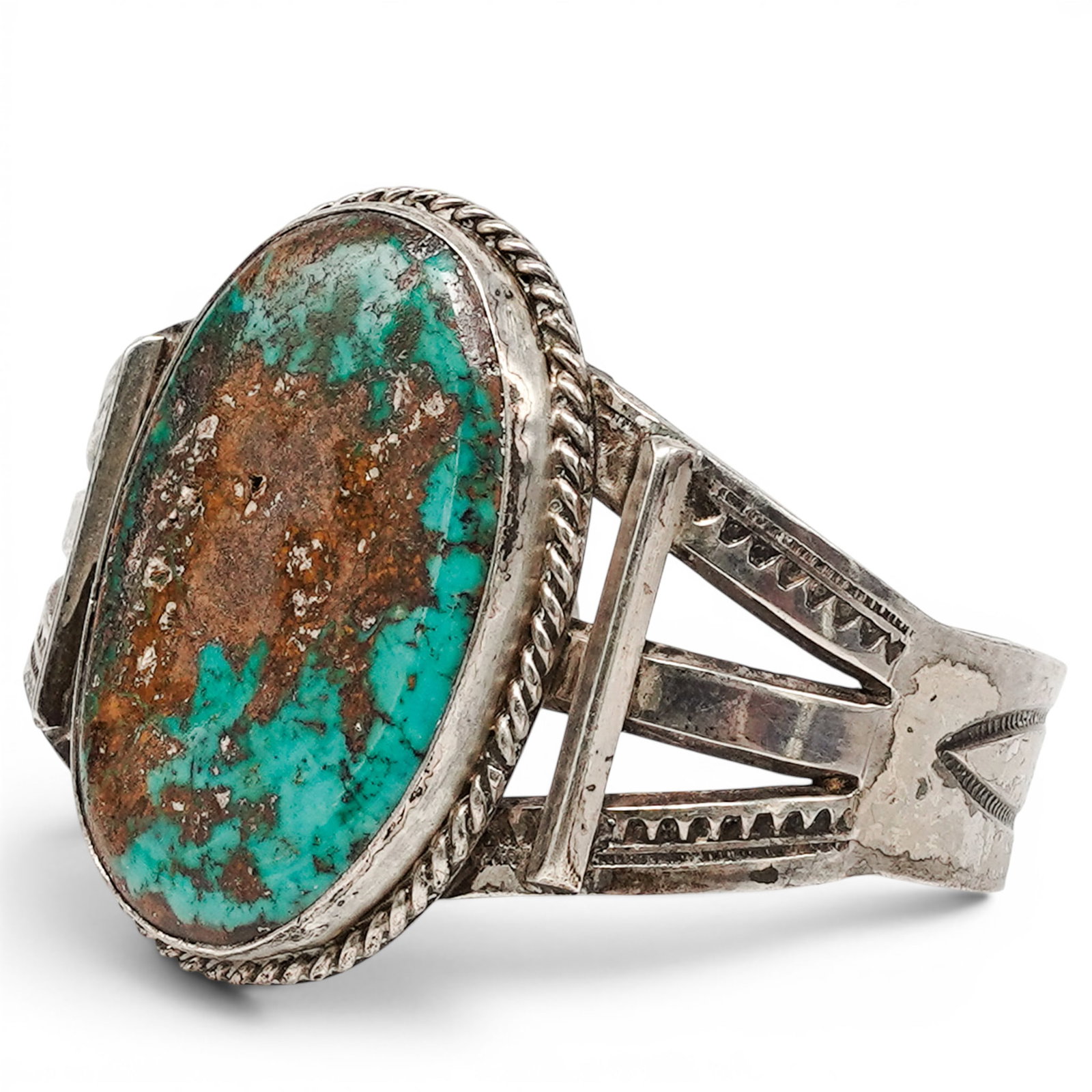 A Navajo Silver And Turquoise Matrix Cuff Bracelet: A Navajo silver and turquoise matrix cuff bracelet Late 20th century Unmarked. Tested sterling silver. A cuff bracelet with a large oval turquoise cabochon exhibiting heavy matrix, set in a rope wire 