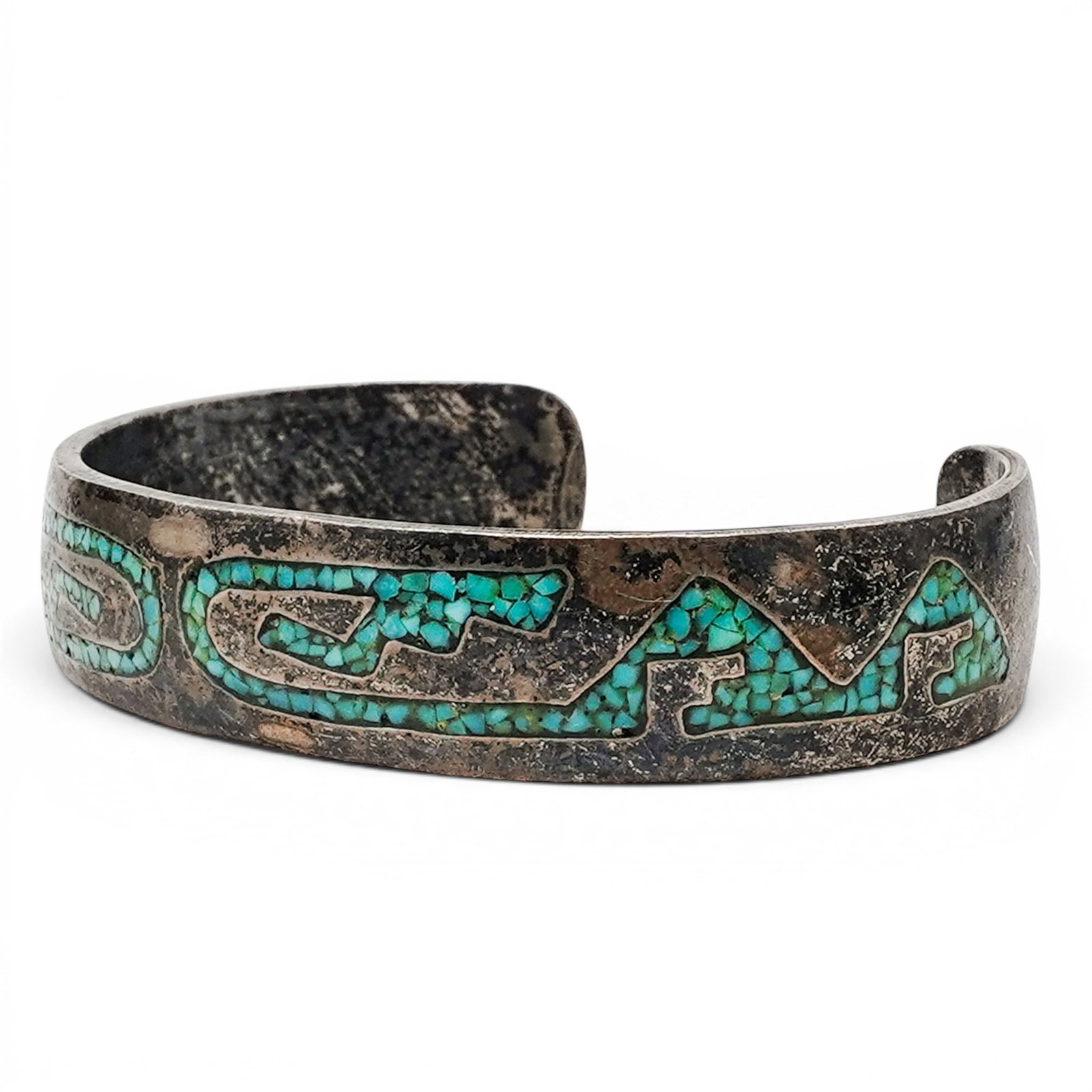 A Navajo Sterling Silver And Turquoise Mosaic Inlay Cuff Bracelet: A Navajo sterling silver and turquoise mosaic inlay cuff bracelet Late 20th century Unmarked. Tested sterling silver. A tapered cuff bracelet with mosaic turquoise inlay forming repeating scrolling an