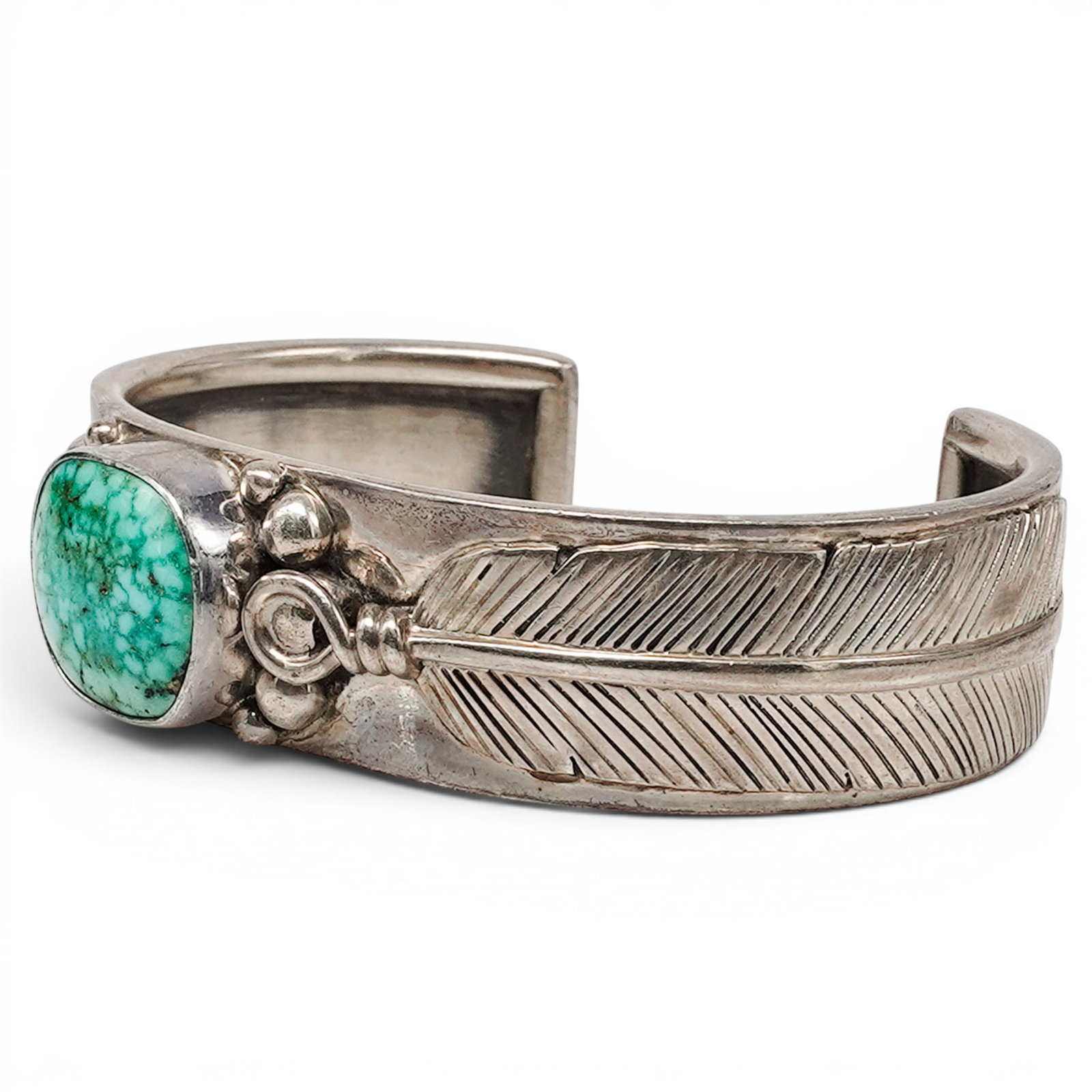 A Nelson Garcia Kewa Sterling Silver And Turquoise Feather Cuff Bracelet: A Nelson Garcia Kewa sterling silver and turquoise feather cuff bracelet Late 20th Century Stamped: N.G. / Sterling. A tapering cuff bracelet formed with an accent overlapping silver feather, centered
