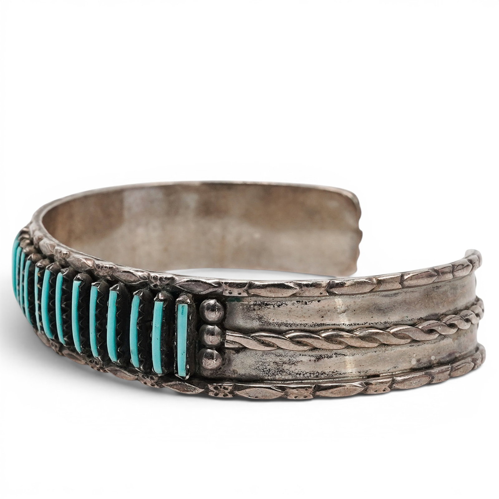 A Navajo Sterling Silver And Turquoise Channel Inlay Cuff Bracelet: A Navajo sterling silver and turquoise channel inlay cuff bracelet Late 20th century Stamped: Y / Sterling. A narrow cuff bracelet with a continuous row of vertical turquoise channel inlay segments, b