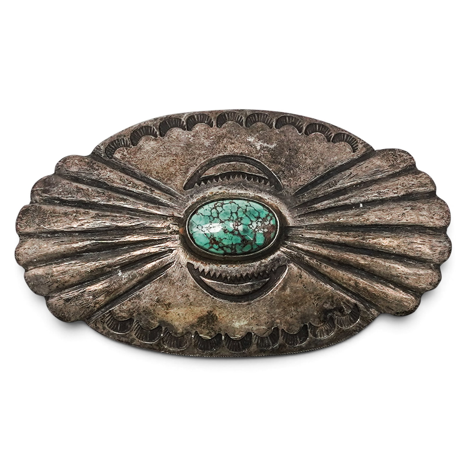 A Charles G. Wallace Sterling Silver And Turquoise Concho Brooch: A Charles G. Wallace sterling silver and turquoise concho brooch Late 20th Century Stamped: UITA 2 / Sterling. An oval concho-form brooch with repoussé fan motifs, stamped border decoration, and a ce