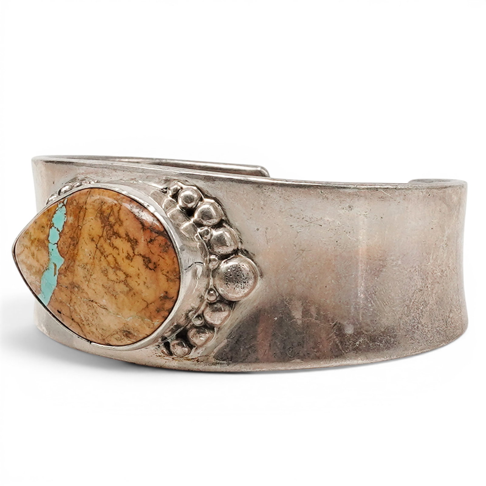 A Nelson Garcia Kewa Silver And Turquoise Matrix Cuff Bracelet: A Nelson Garcia Kewa silver and turquoise matrix cuff bracelet Late 20th century Stamped: N.G. / Sterling A wide silver cuff bracelet with a large oval turquoise cabochon exhibiting heavy brown matrix