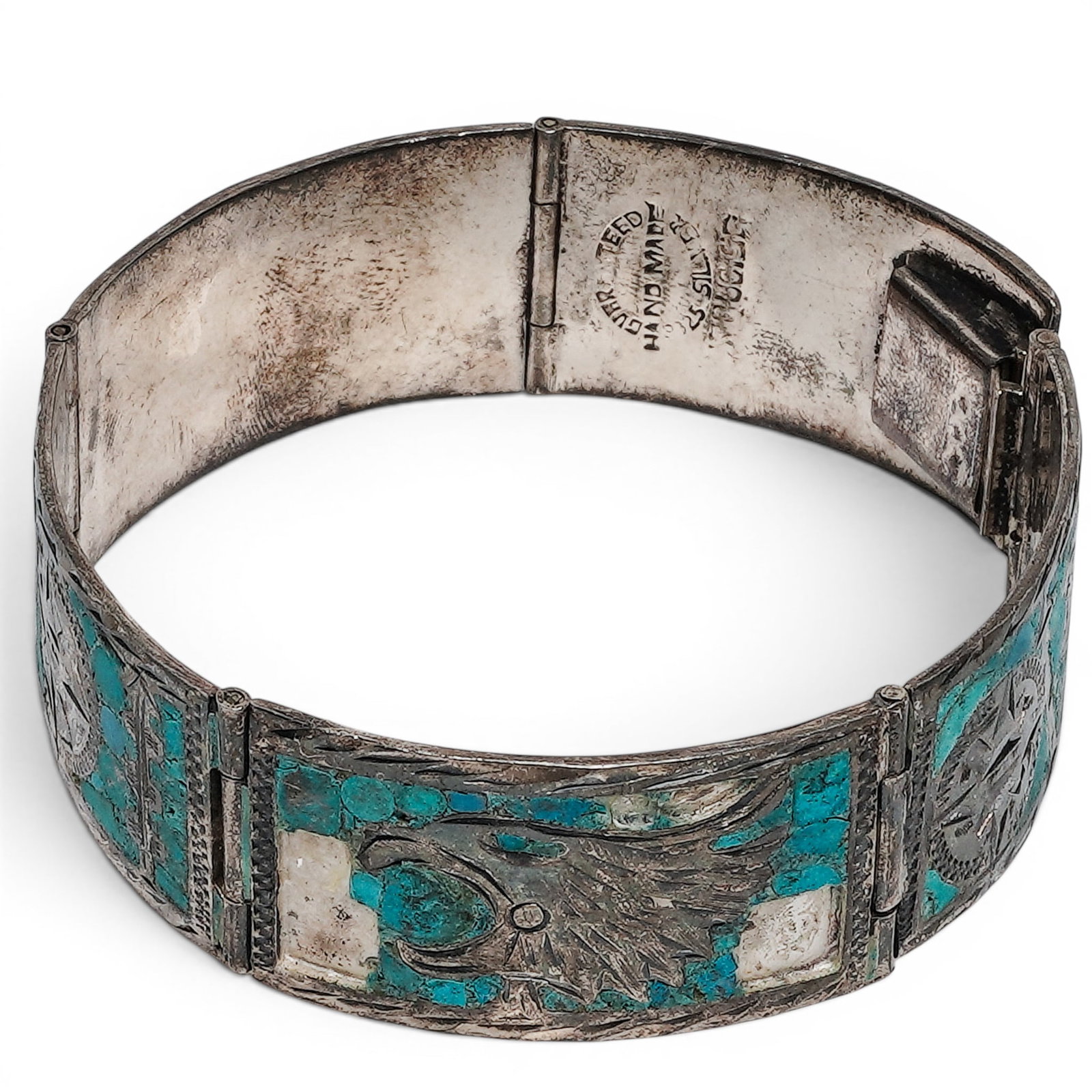 A Navajo Sterling Silver And Turquoise Chip Inlay Hinged Cuff Bracelet: A Navajo sterling silver and turquoise chip inlay hinged cuff bracelet Late 20th century Stamped: Guaranteed Handmade .925 Silver Turquoise. A hinged panel bracelet composed of rectangular silver link