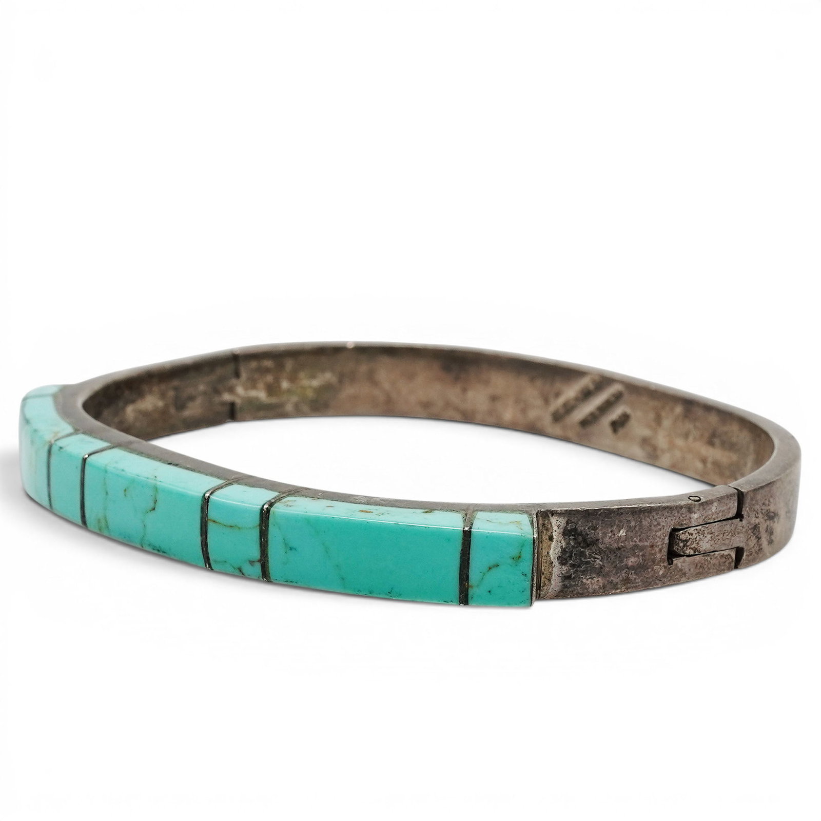 A Mexican Sterling Silver And Turquoise Inlay Hinged Bangle Bracelet: A Mexican sterling silver and turquoise inlay hinged bangle bracelet Late 20th century, Mexican Stamped: 925 / illegible hallmark / Mexico. A hinged sterling silver bangle bracelet with a continuous r