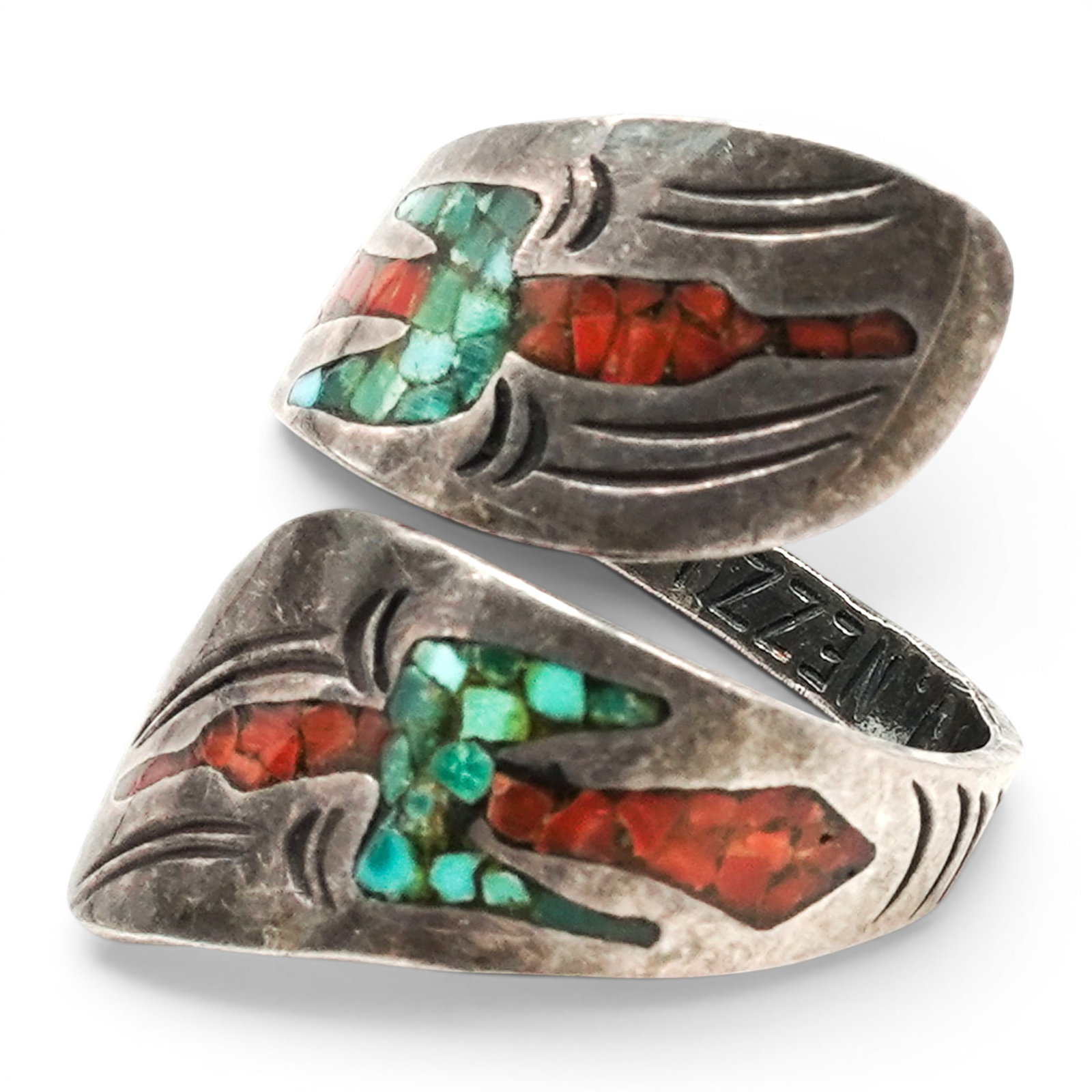 A Jimmie Nezzie Navajo Sterling Silver, Turquoise, And Coral Inlay Bypass Ring: A Jimmie Nezzie Navajo sterling silver, turquoise, and coral inlay bypass ring Late 20th century Stamped: J. Nezzie. Tested sterling silver. A bypass-style ring with opposing shield-form terminals, ea