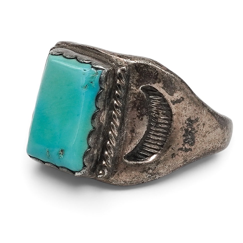 A Navajo Sterling Silver And Square Turquoise Stampwork Ring: A Navajo sterling silver and square turquoise stampwork ring Late 20th century Unmarked. Tested sterling silver. A tapered ring set with a square turquoise cabochon in a serrated bezel, with hand-stam