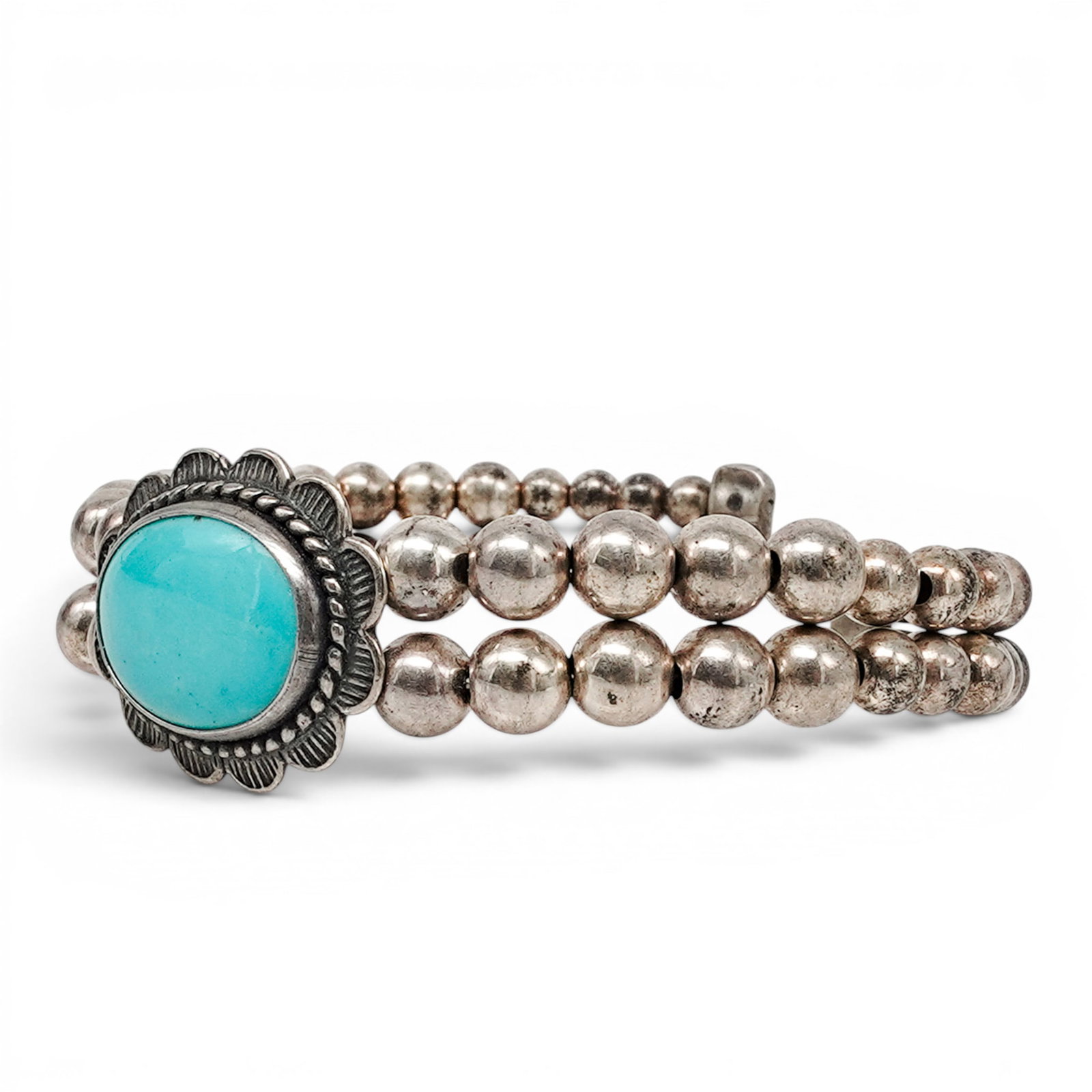 A Relios Southwest Sterling Silver And Turquoise Beadwork Cuff Bracelet: A Relios Southwest sterling silver and turquoise beadwork cuff bracelet Late 20th century Stamped: Relios hallmark / .925. A cuff bracelet with a central oval bezel set turquoise cabochon framed by ro