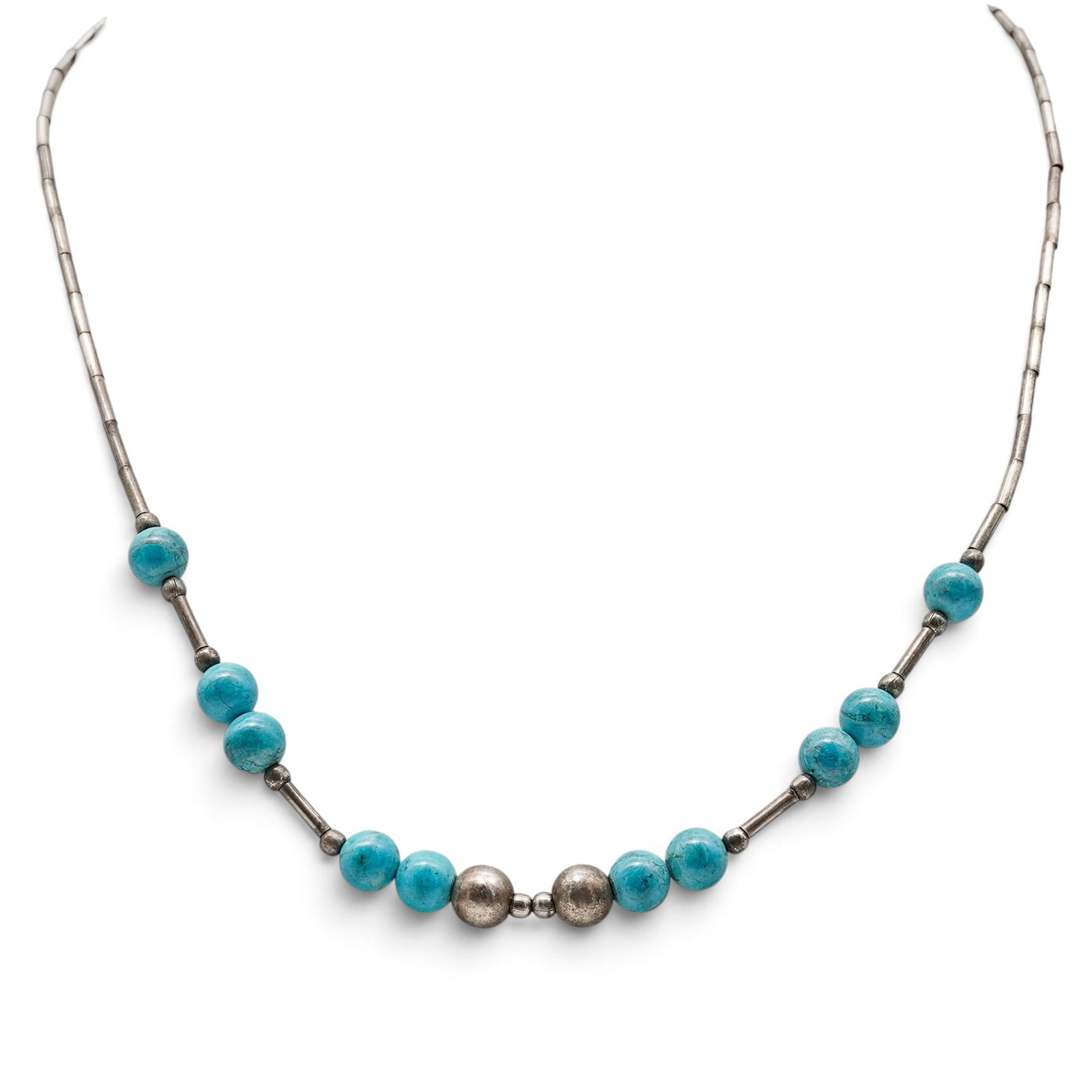 A Navajo Sterling Silver And Turquoise Bead Station Necklace: A Navajo sterling silver and turquoise bead station necklace Late 20th century Unmarked. Tested sterling silver. A necklace with silver tube beads and scattered turquoise bead stations arranged asymme
